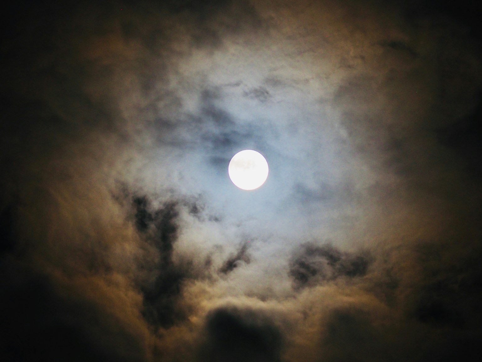 Helle Mond umgeben von dunklen Wolken