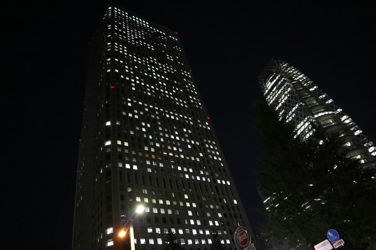Beleuchtete Wolkenkratzer in einer Stadt bei Nacht mit hellen Fenstern