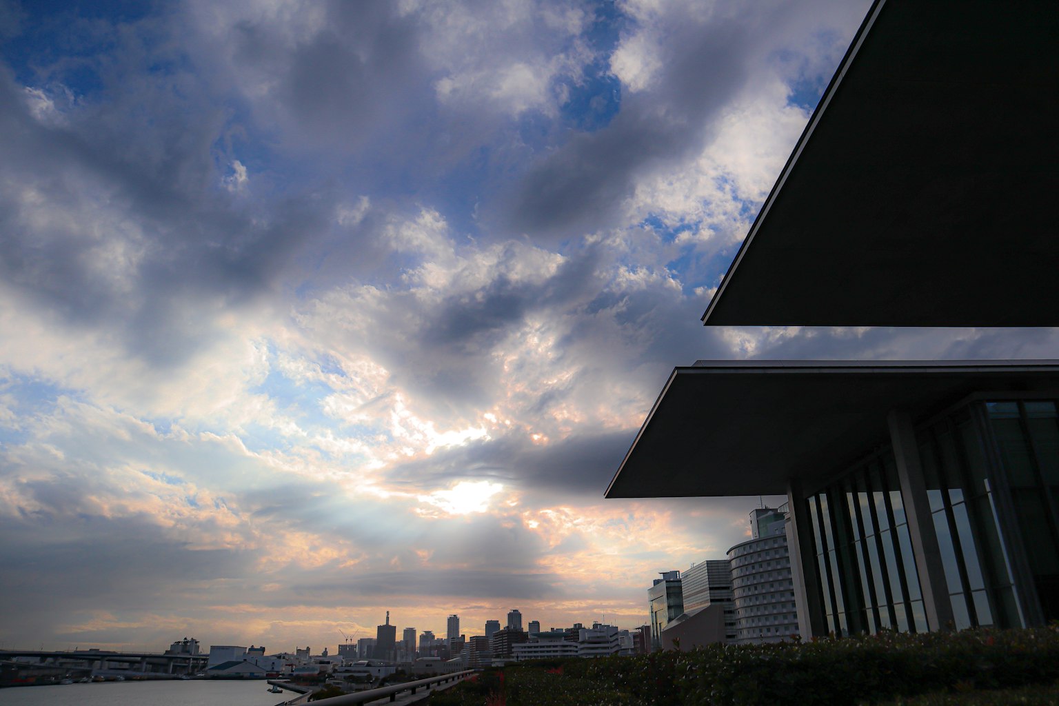 Silhouette di un edificio moderno contro un cielo drammatico con nuvole e skyline della città