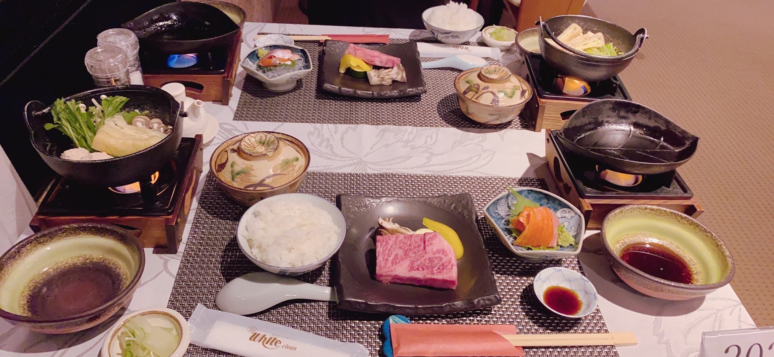 Ein Tisch mit verschiedenen japanischen Gerichten und heißen Töpfen