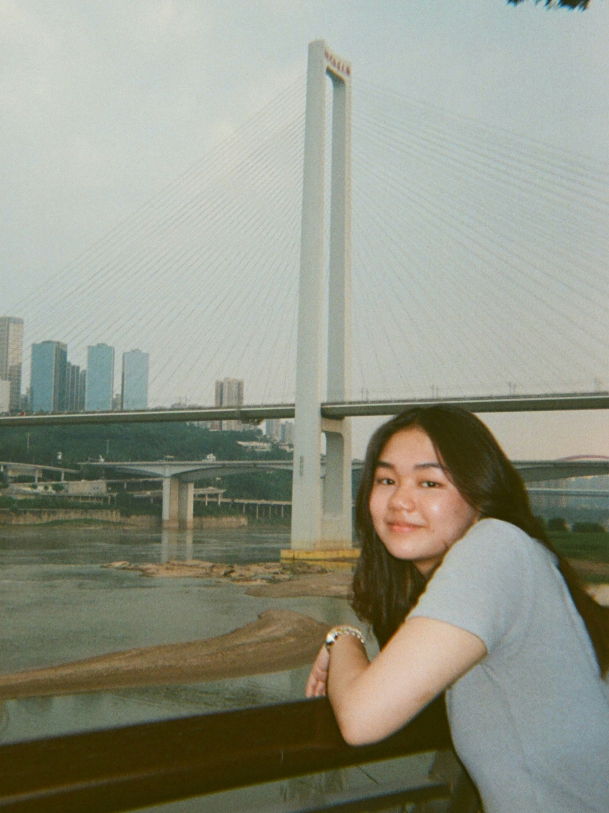 川沿いの橋を背景にした女性のポートレート