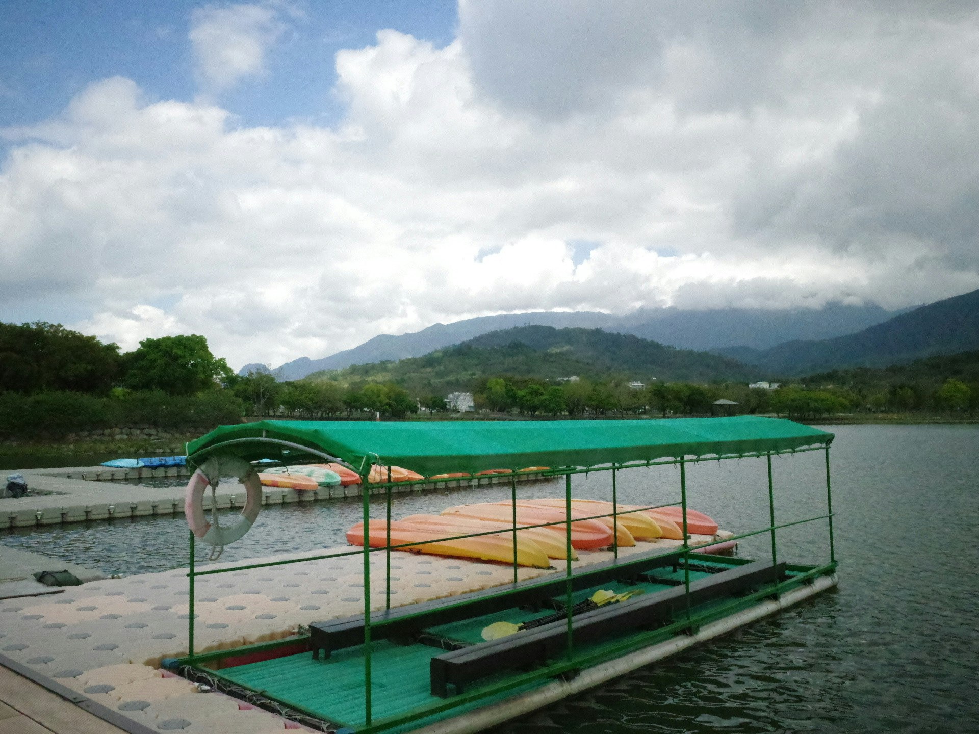 台湾の湖畔に浮かぶ緑のボートとカヤック