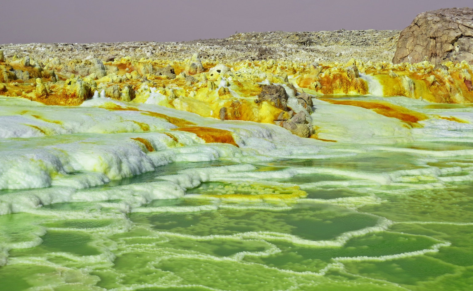Landscape of the Dead Sea featuring green water and yellow minerals