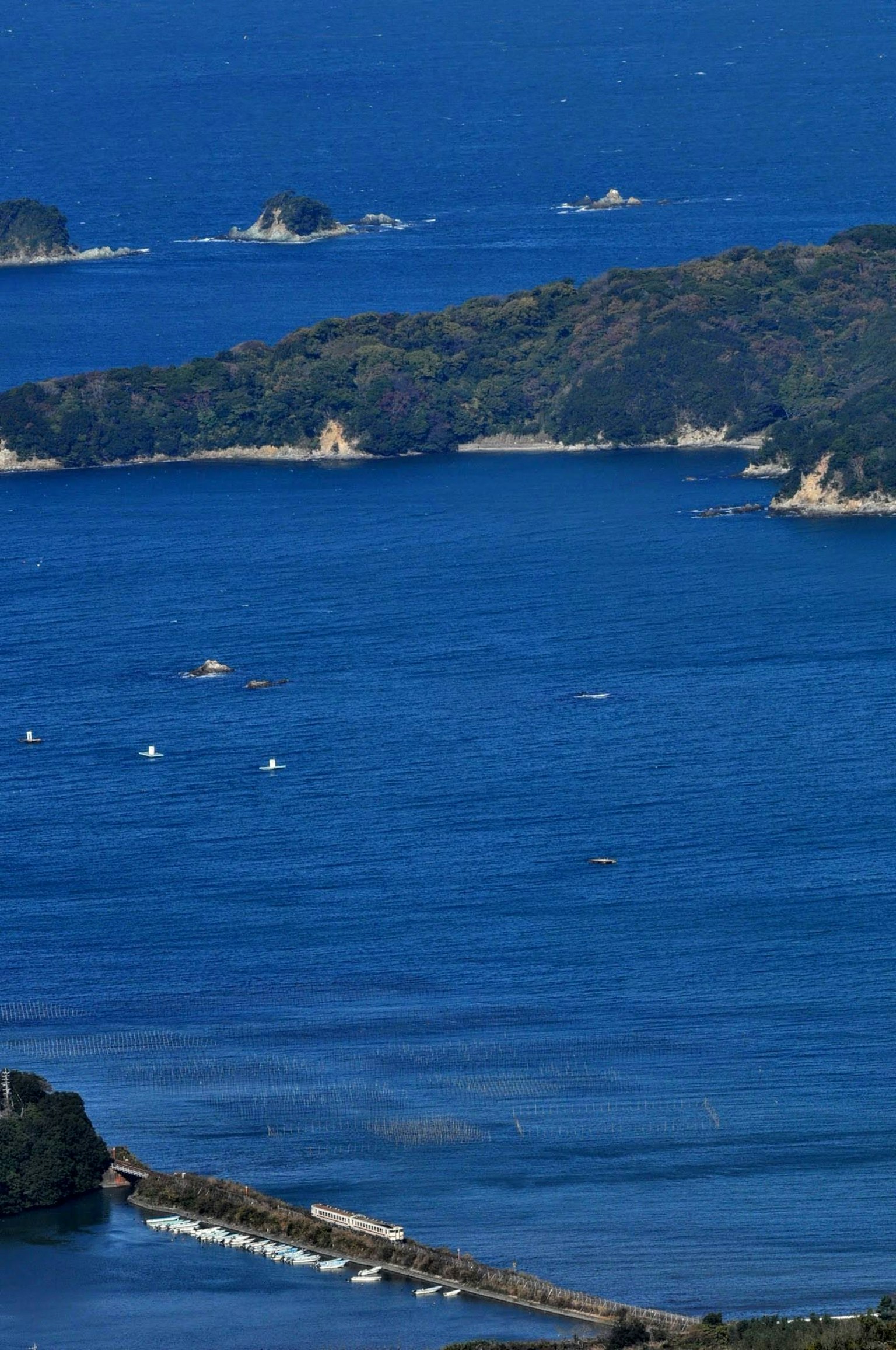 ทิวทัศน์ของทะเลสีน้ำเงินที่มีเกาะเล็กและเรือกระจายอยู่