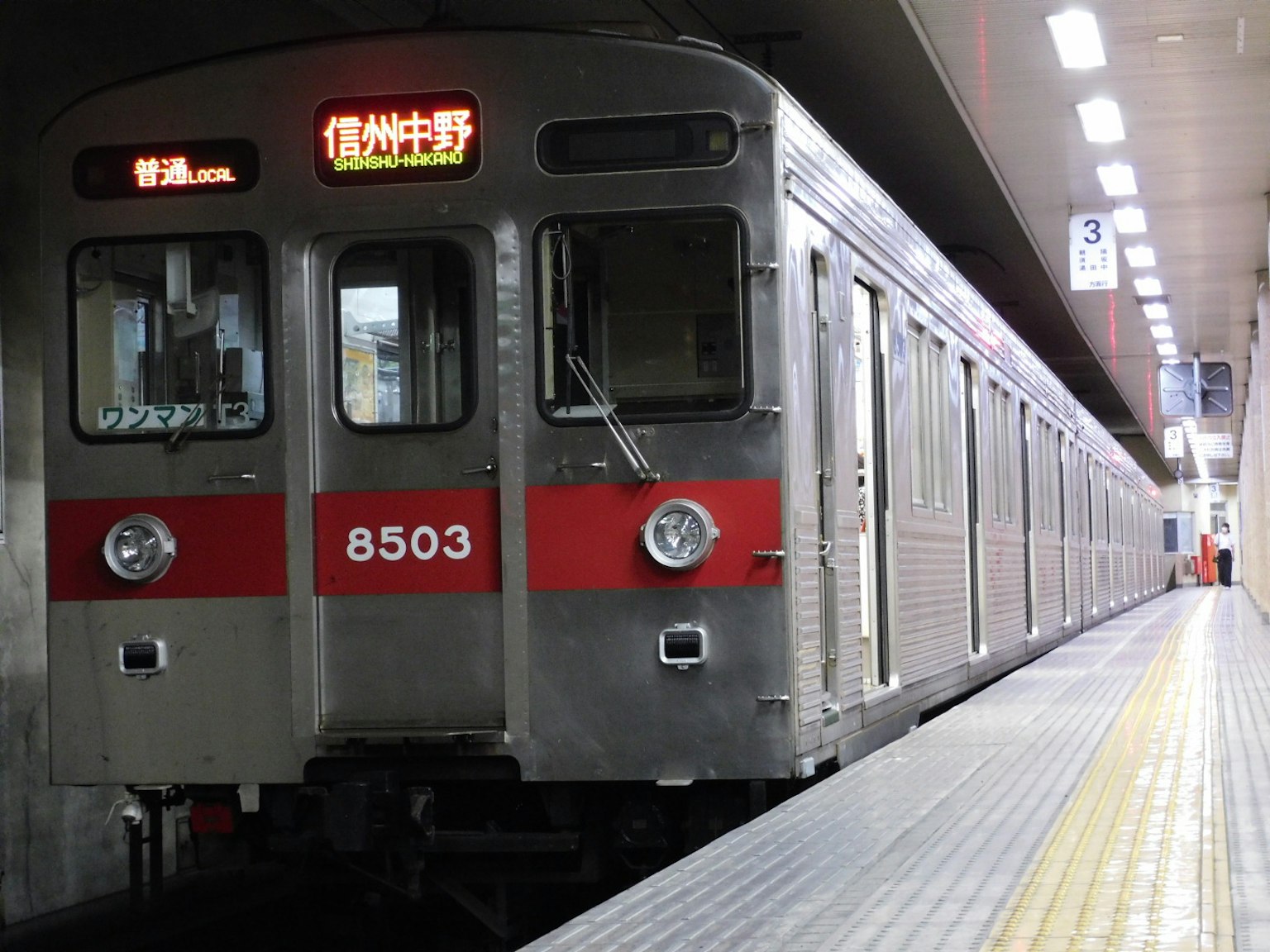 銀色列車帶紅色條紋停在車站