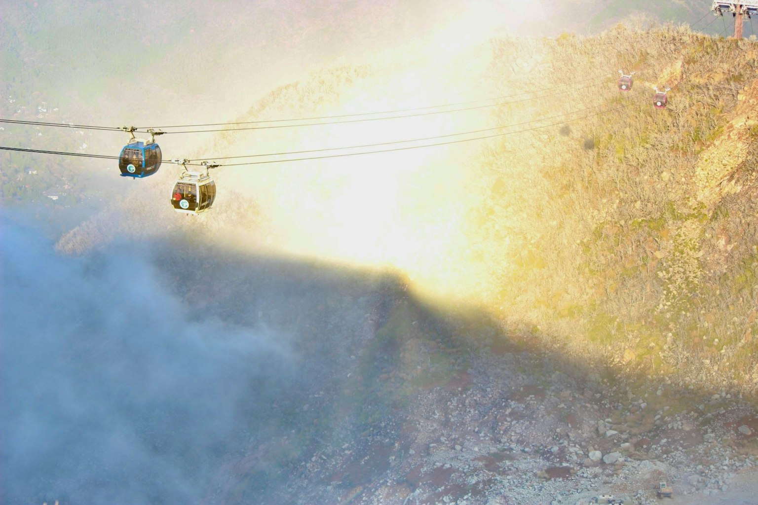 Cable cars moving through mist and sunlight