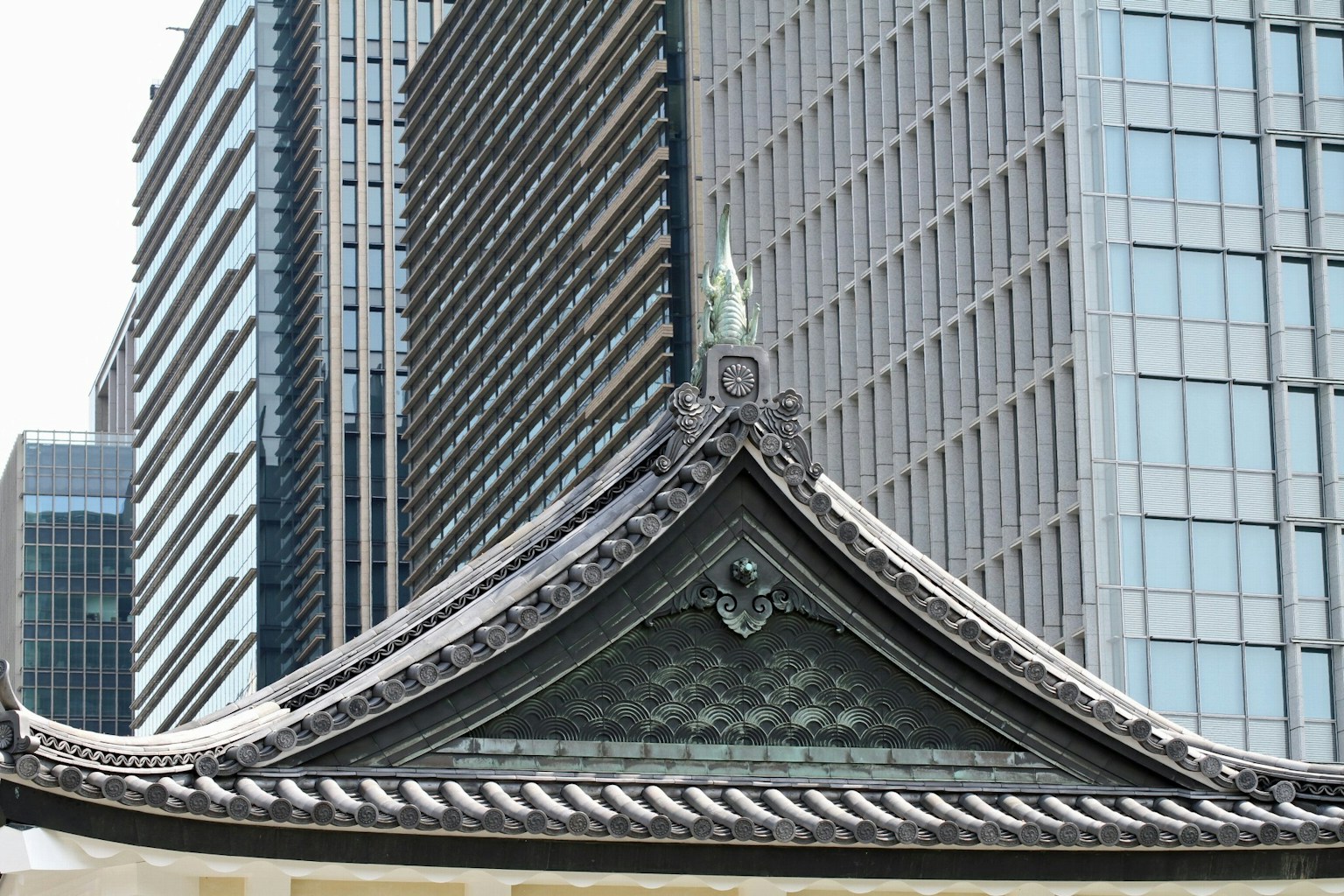 Traditional Japanese temple roof against a modern skyscraper background