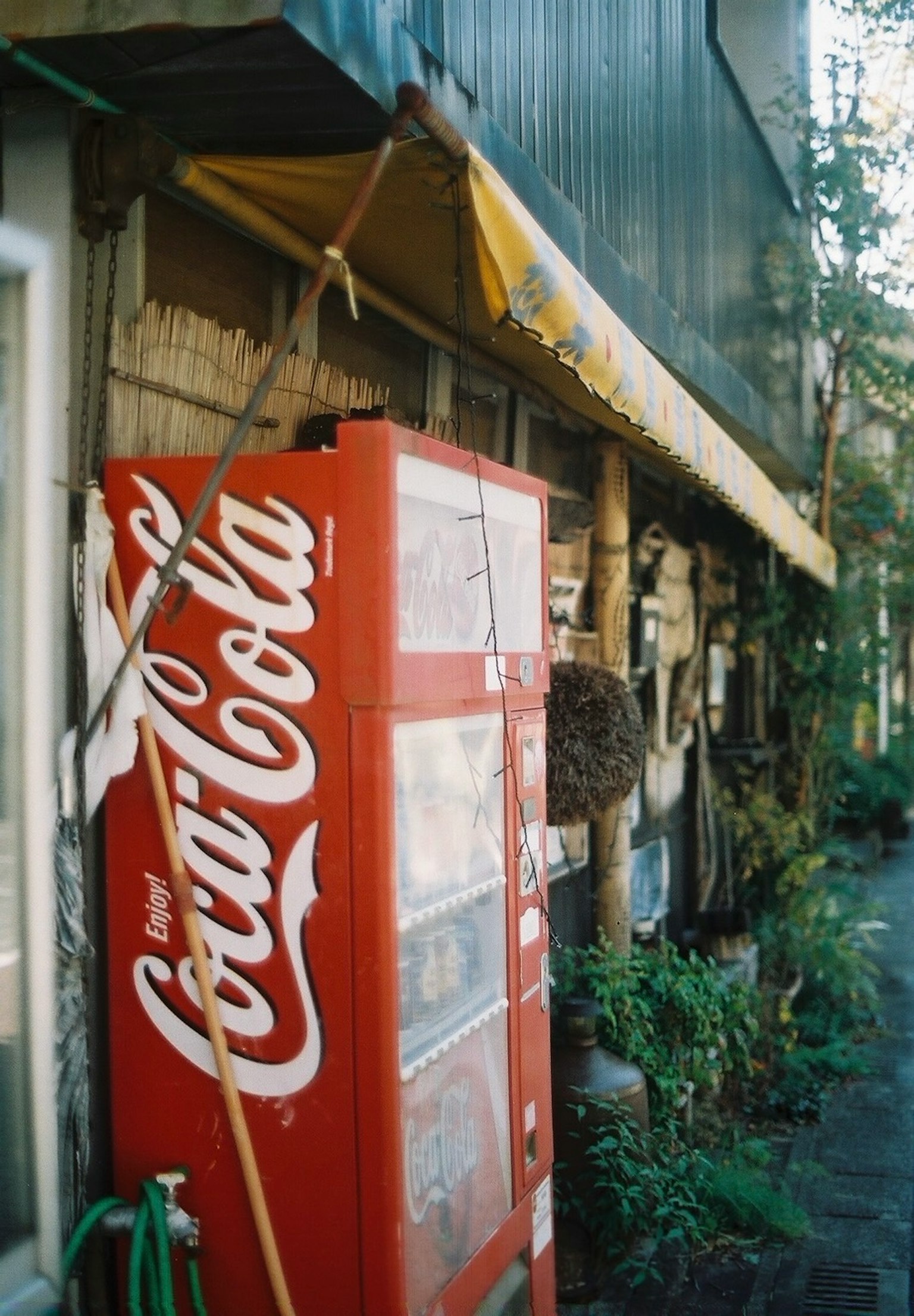 Esterno di un vecchio edificio con un distributore automatico Coca-Cola rosso