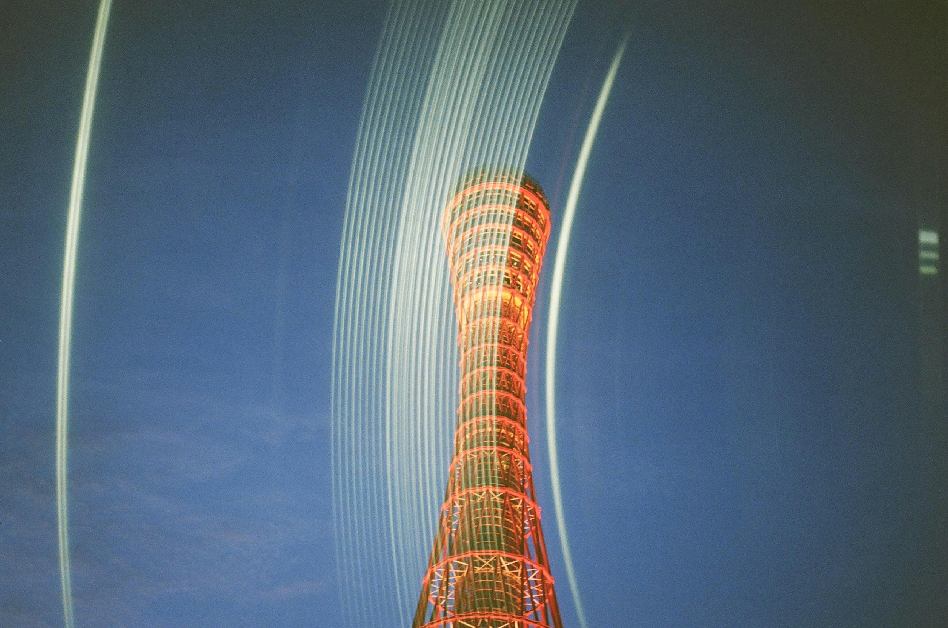 夜の青い空にそびえるオレンジ色のタワー