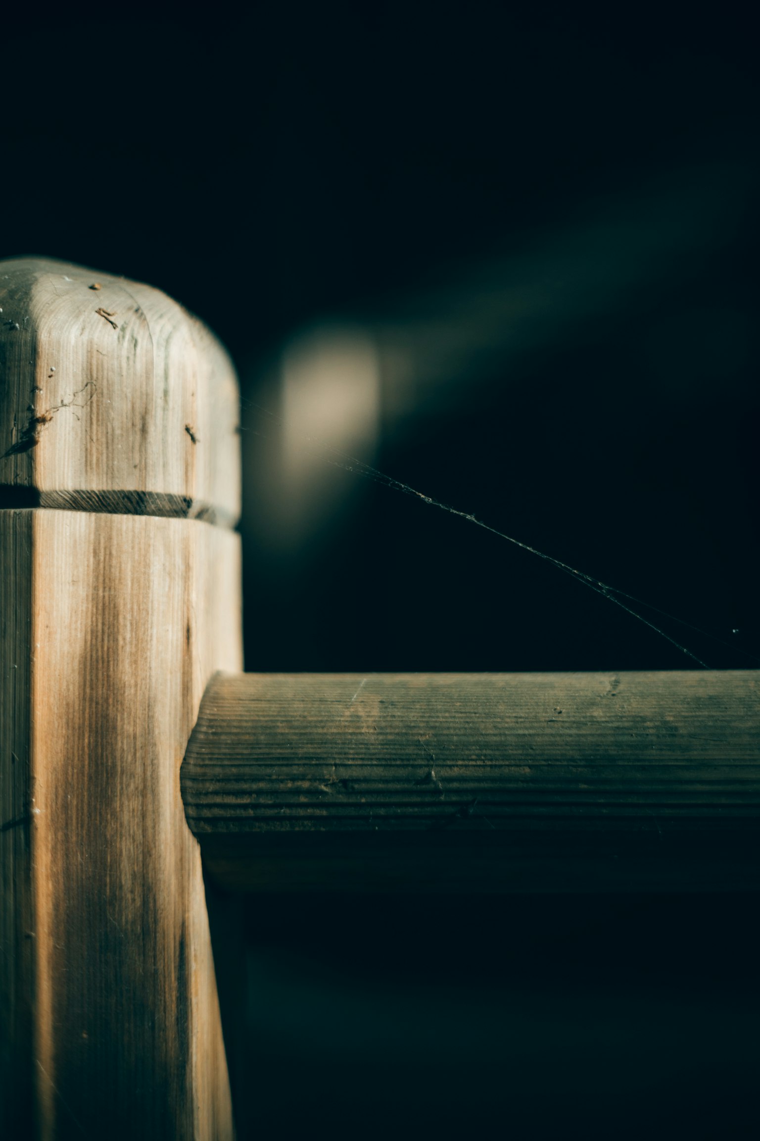 Nahaufnahme eines Holzpfostens mit dunklem Hintergrund