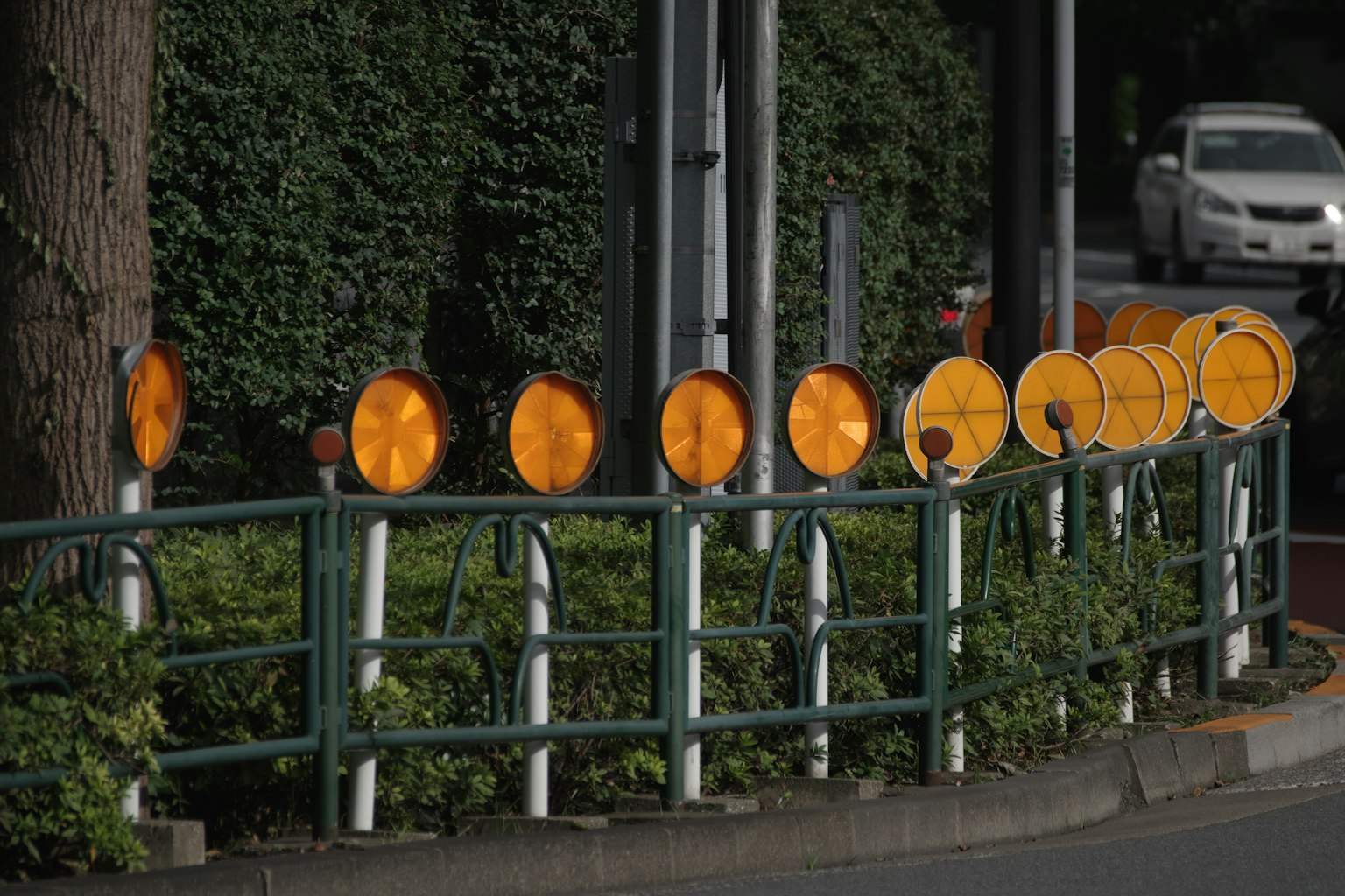 Deretan lampu peringatan oranye di sepanjang trotoar