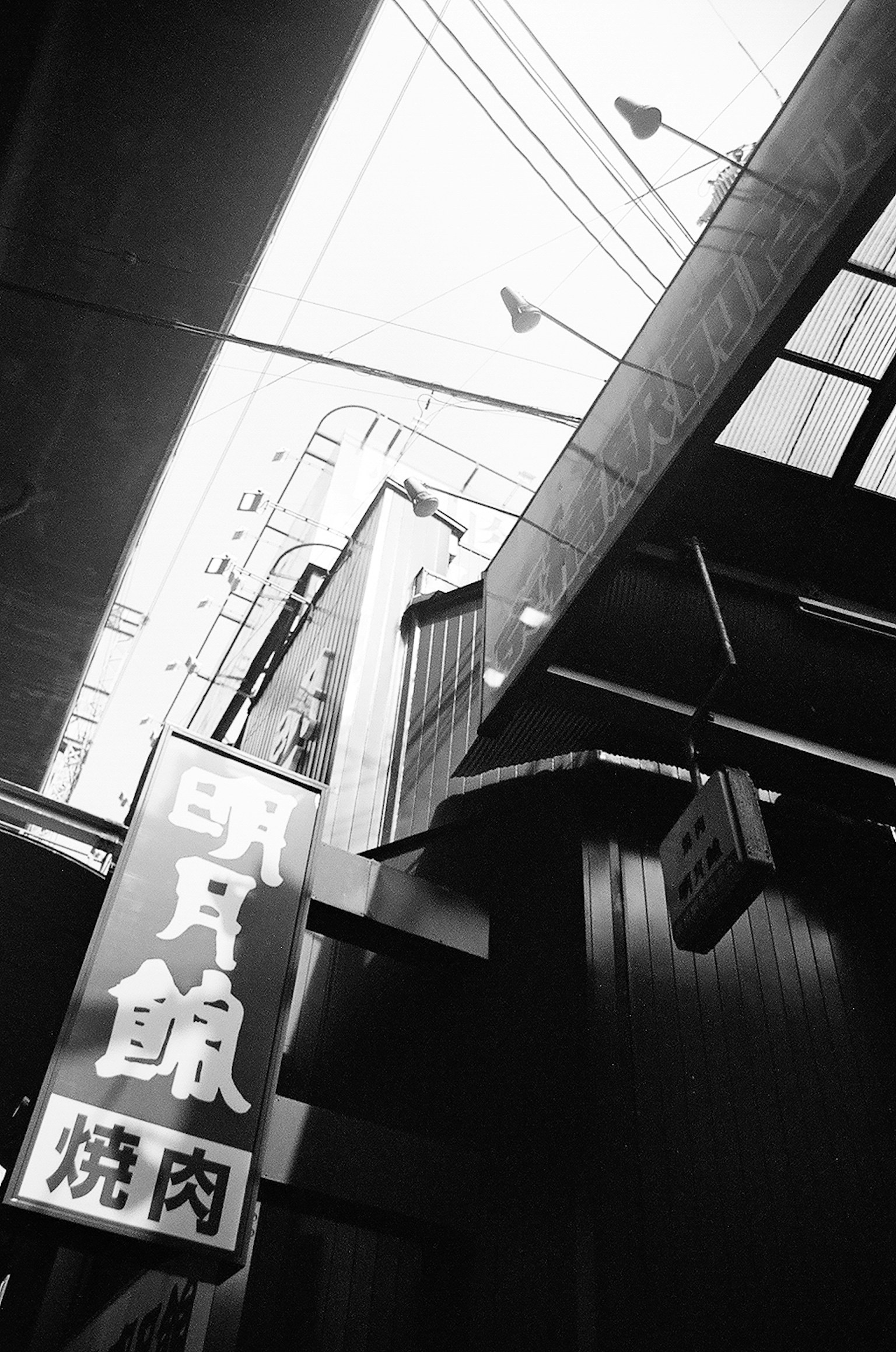 Black and white photo of an urban scene featuring unique signage and lighting