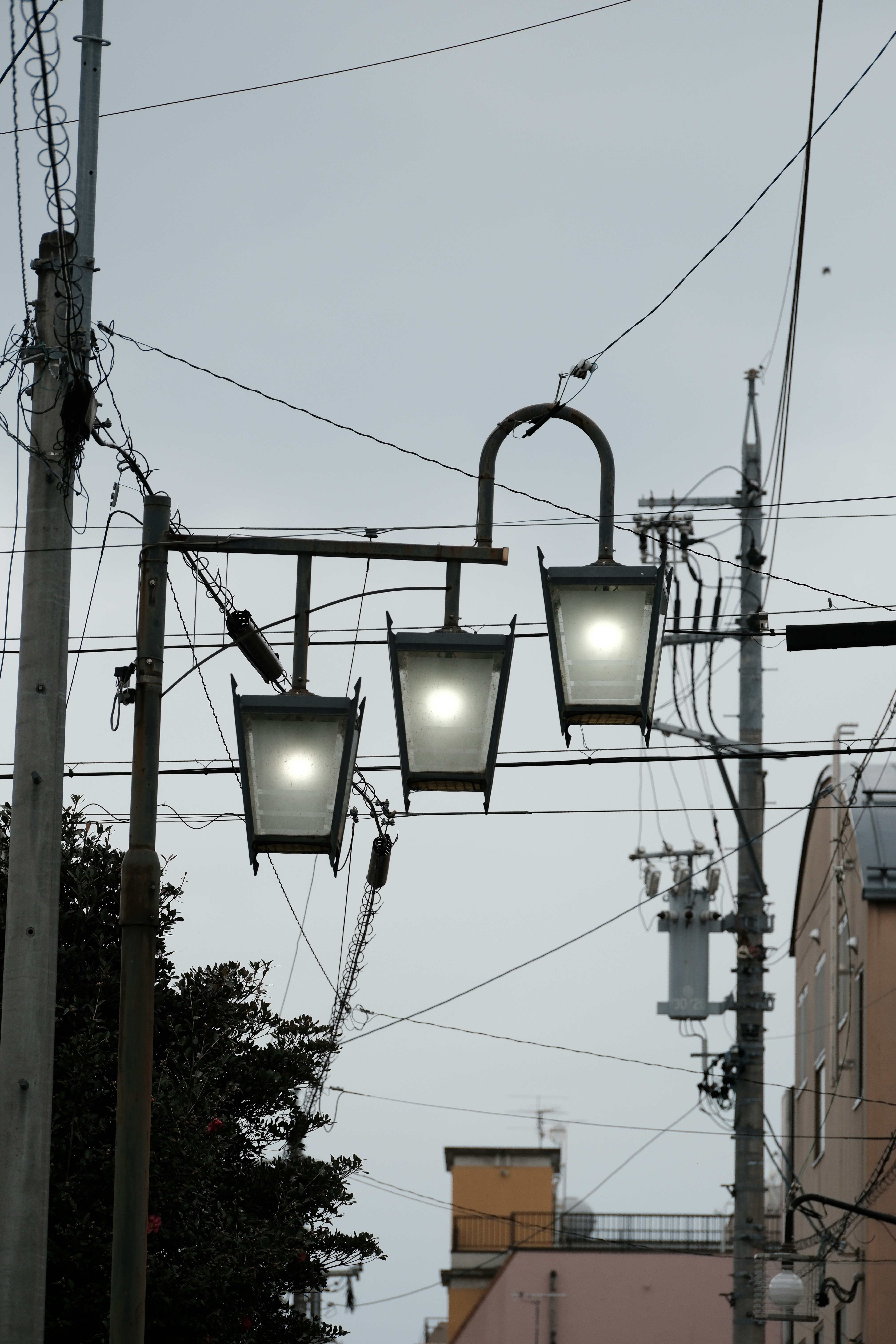 night view of streetlights hanging over overhead wires in an alley