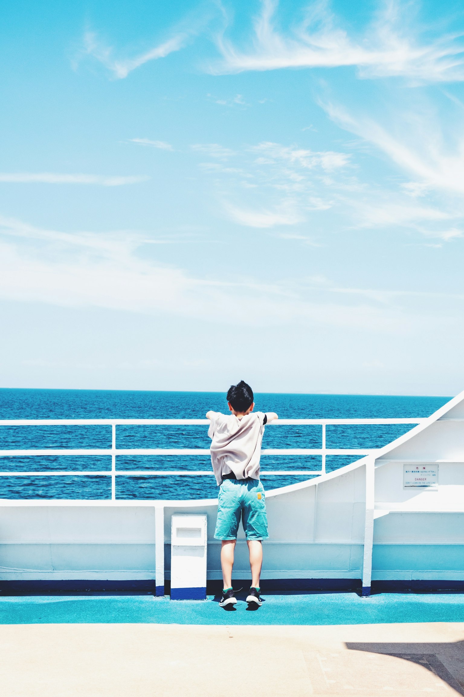 Man looking at the blue ocean from a deck