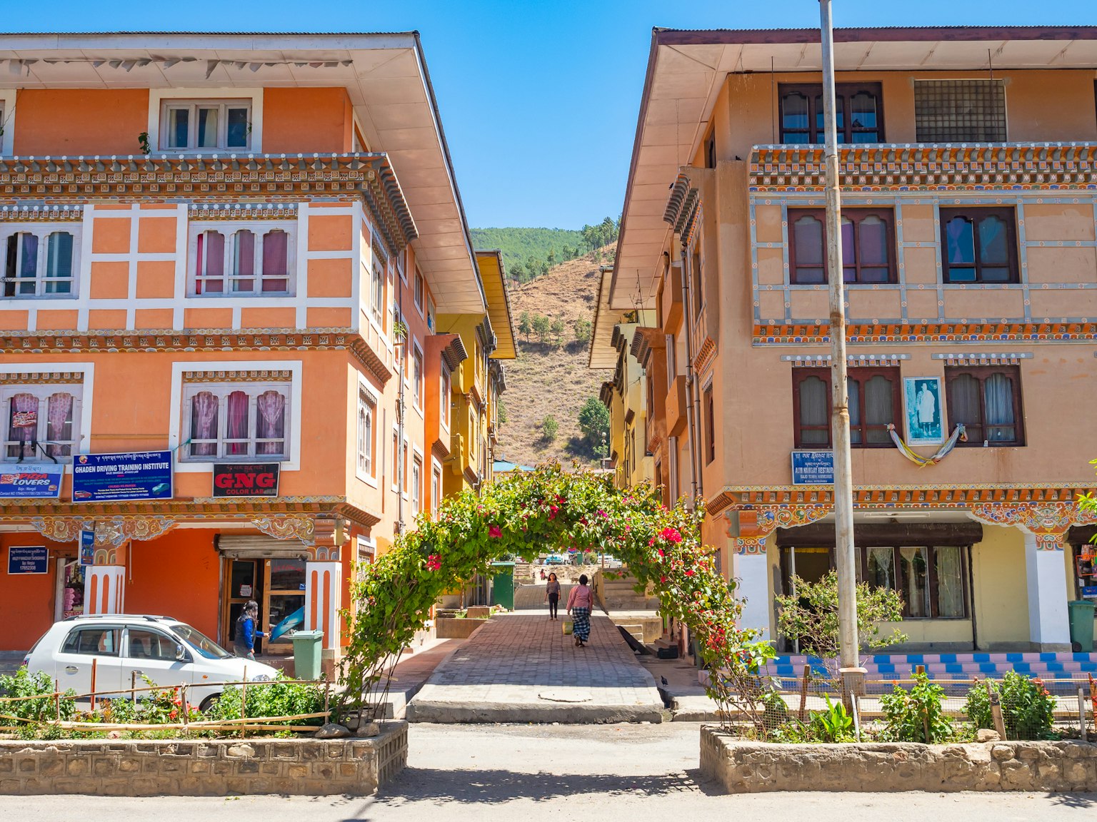 Edifici colorati che fiancheggiano una strada con una collina verde sullo sfondo