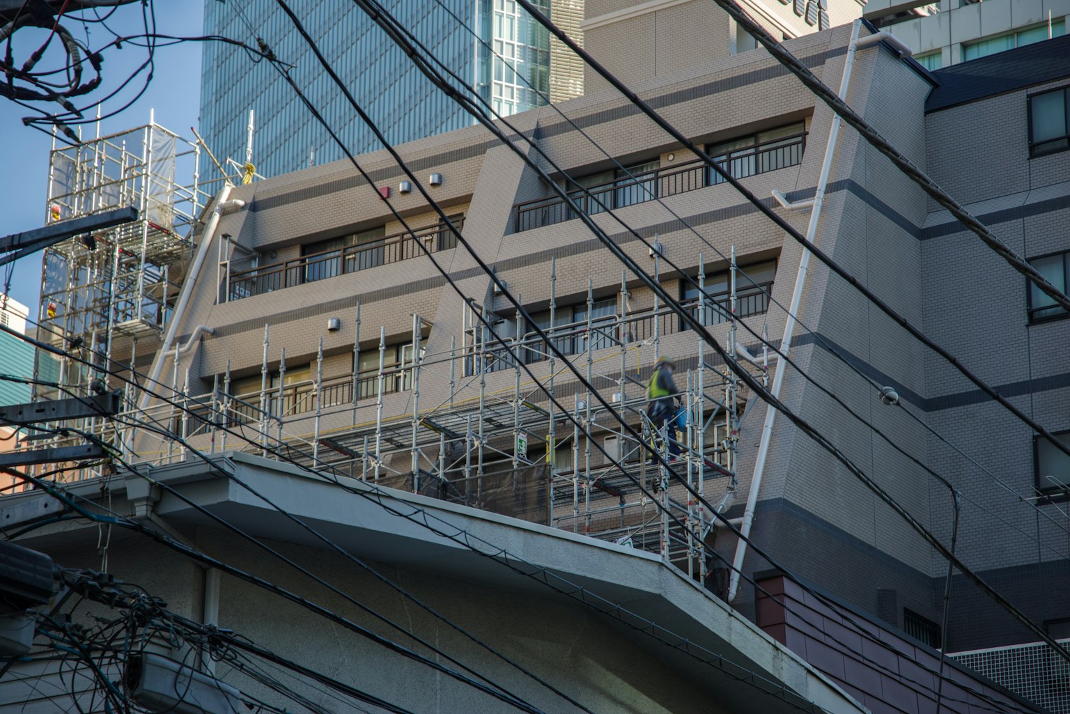 Edificio in costruzione vicino a un grattacielo con linee elettriche visibili