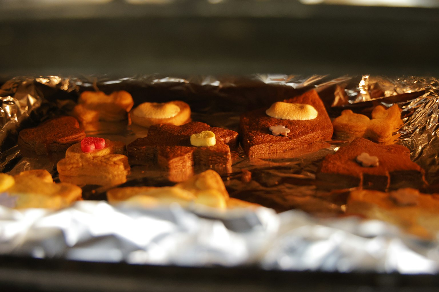 Biscuits en train de cuire dans le four sur un plateau tapissé de papier aluminium