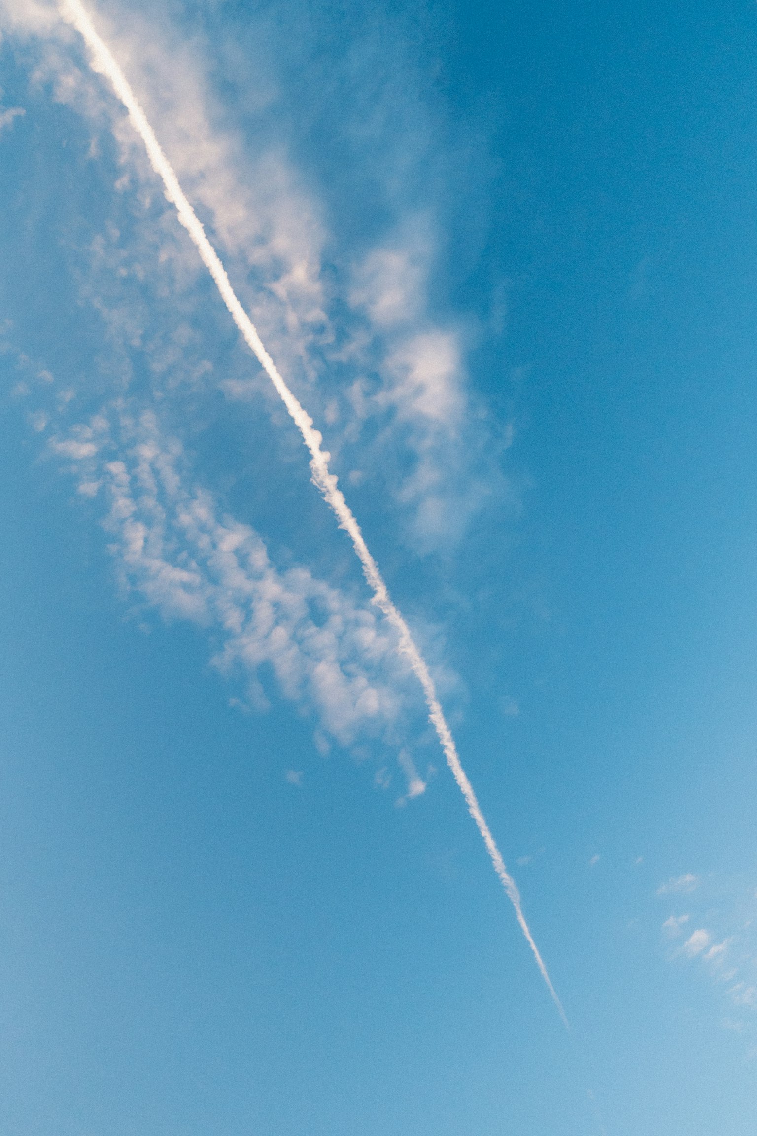 Une traînée blanche s'étend à travers un ciel bleu