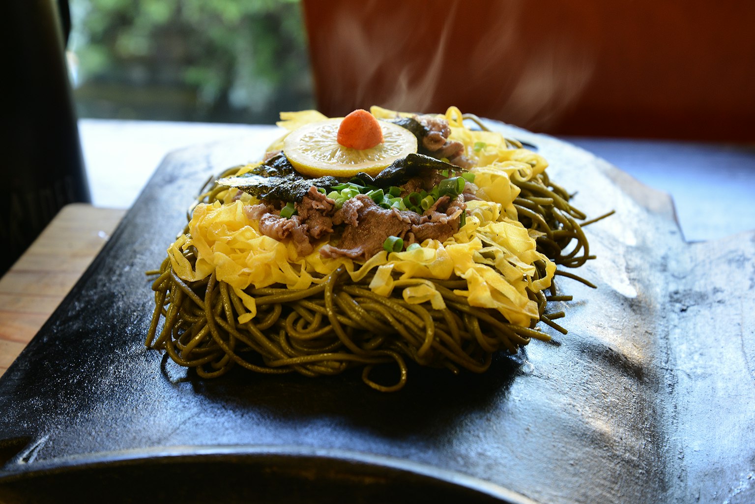 Hidangan mie goreng dengan telur dan daging di atasnya