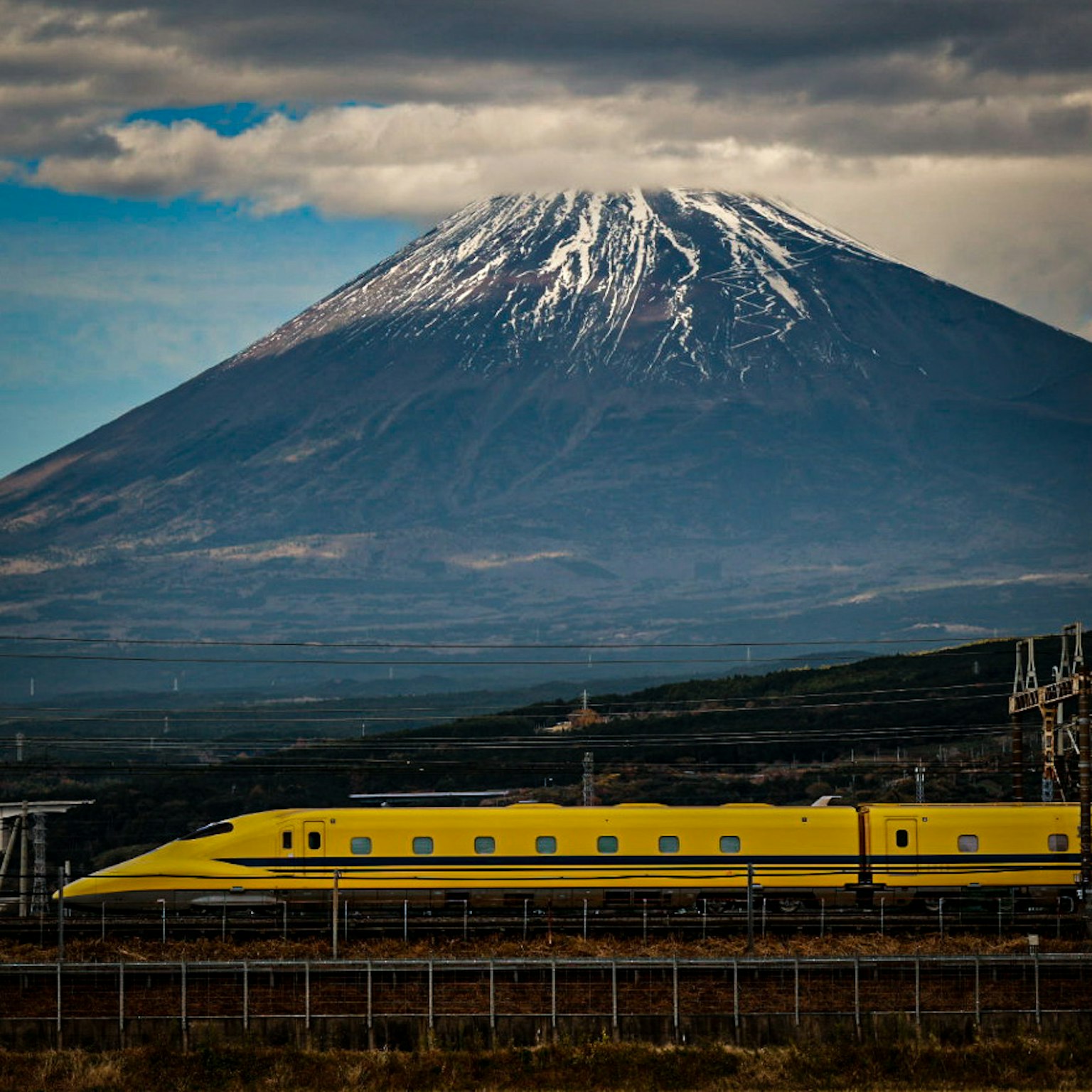 Treno Shinkansen giallo con il monte Fuji sullo sfondo