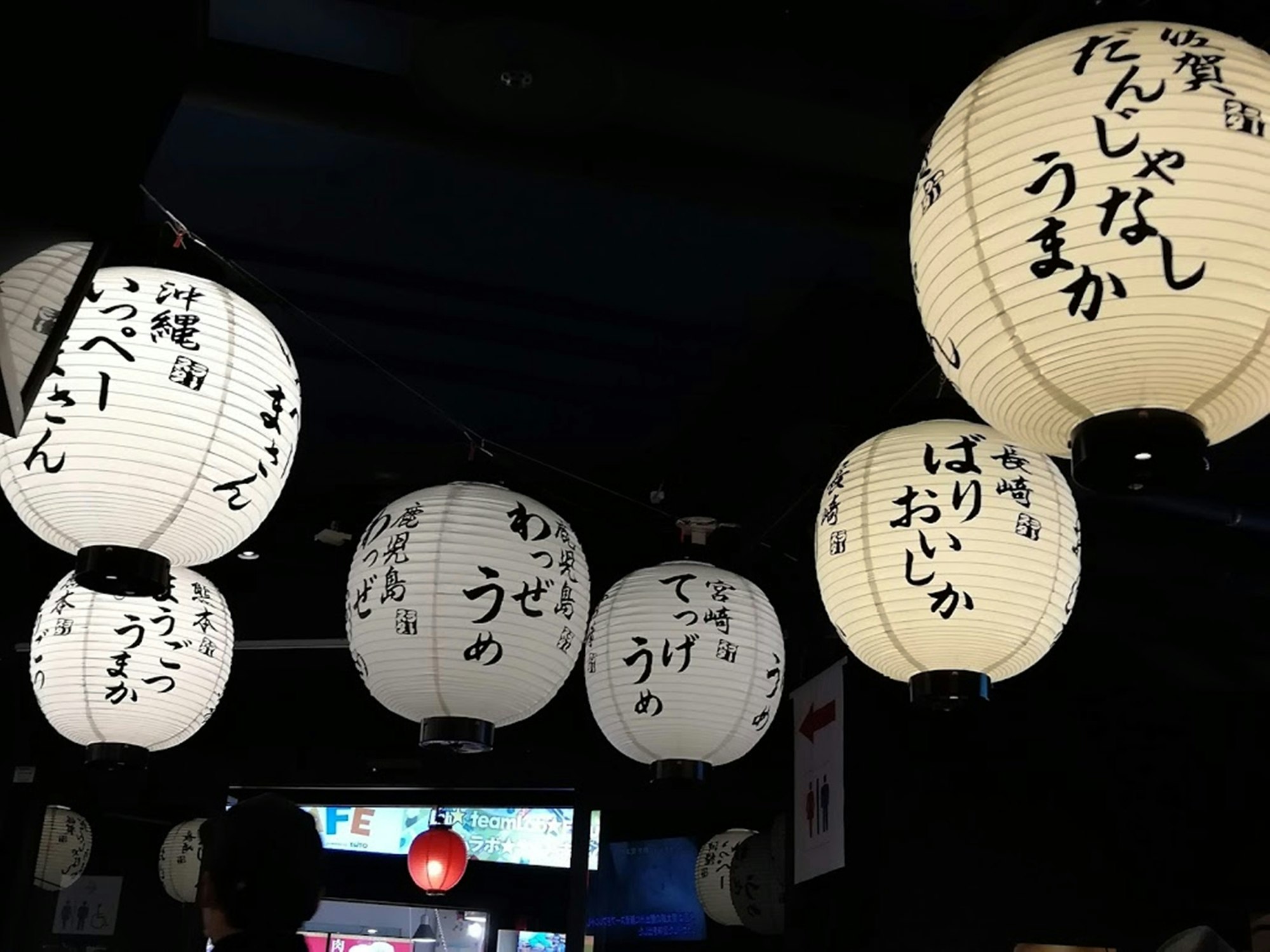 提灯に書かれた文字が並ぶ夜の屋内空間