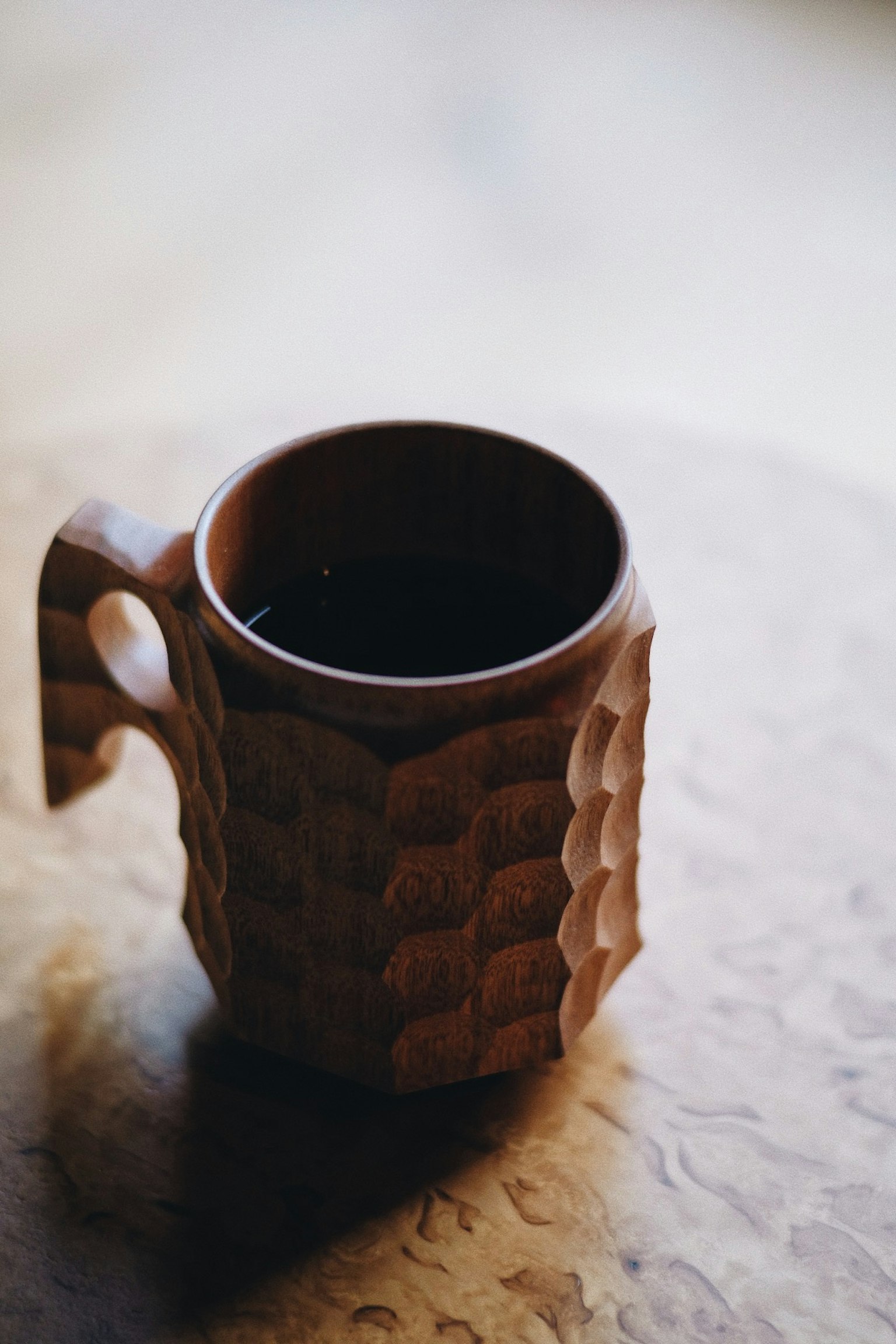 Taza de madera decorativa colocada sobre una mesa