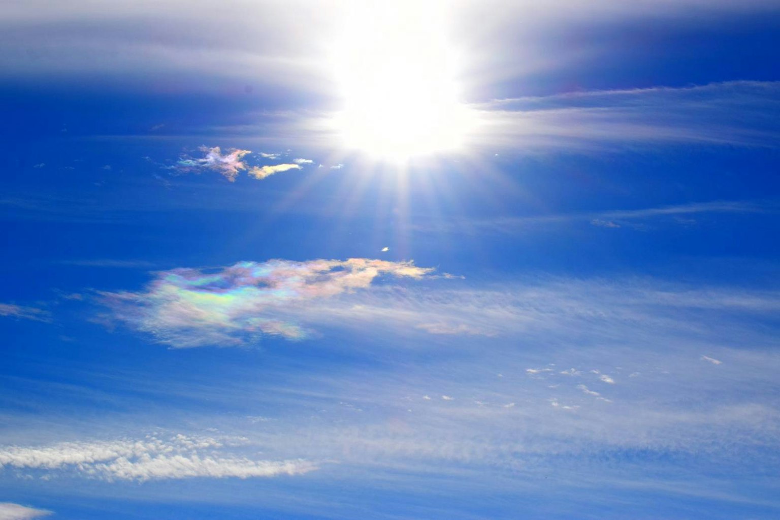 Matahari cerah di langit biru dengan awan berwarna