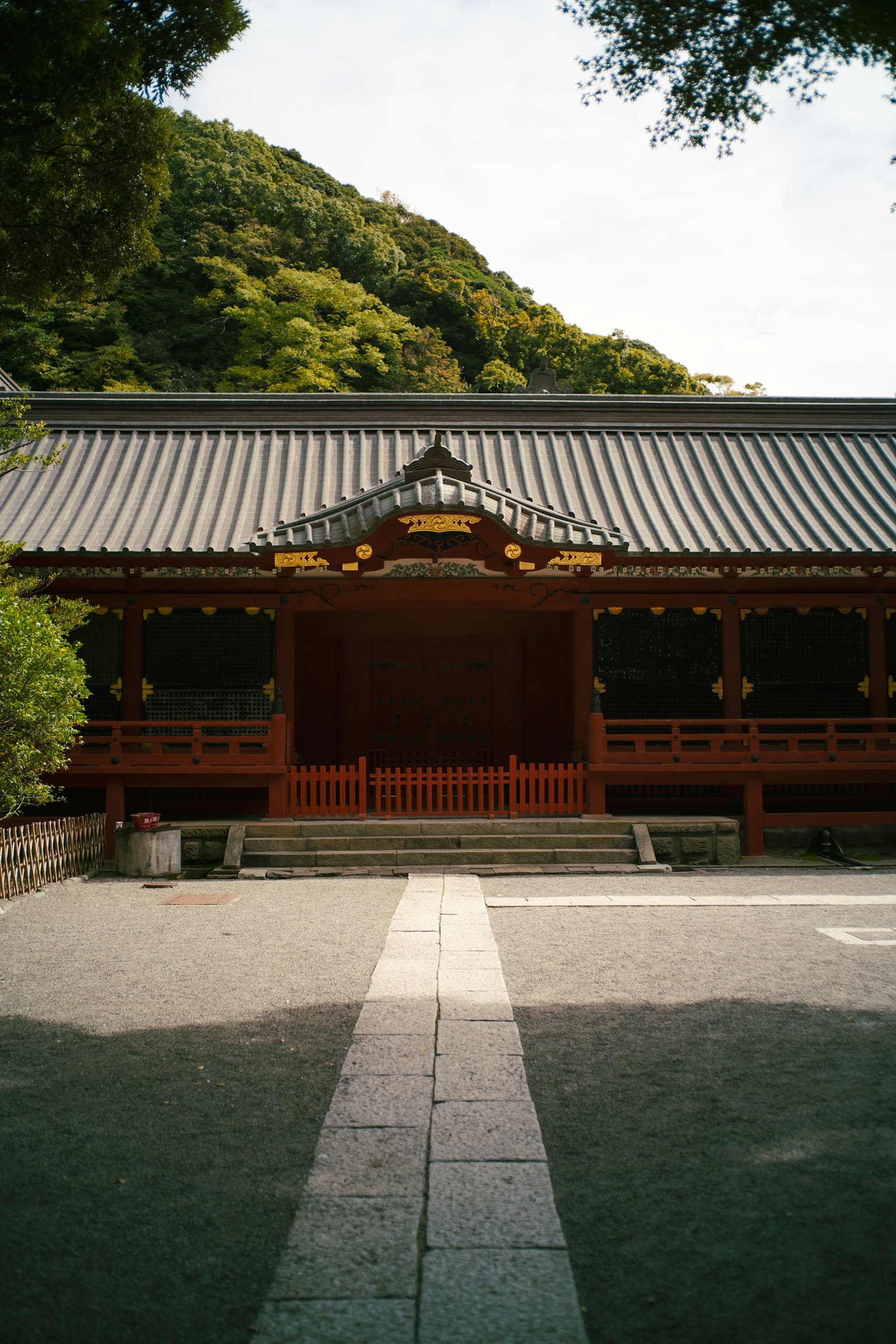 아름다운 일본 사원의 외관, 빨간 나무 구조물, 녹색 산 배경, 고요한 정원