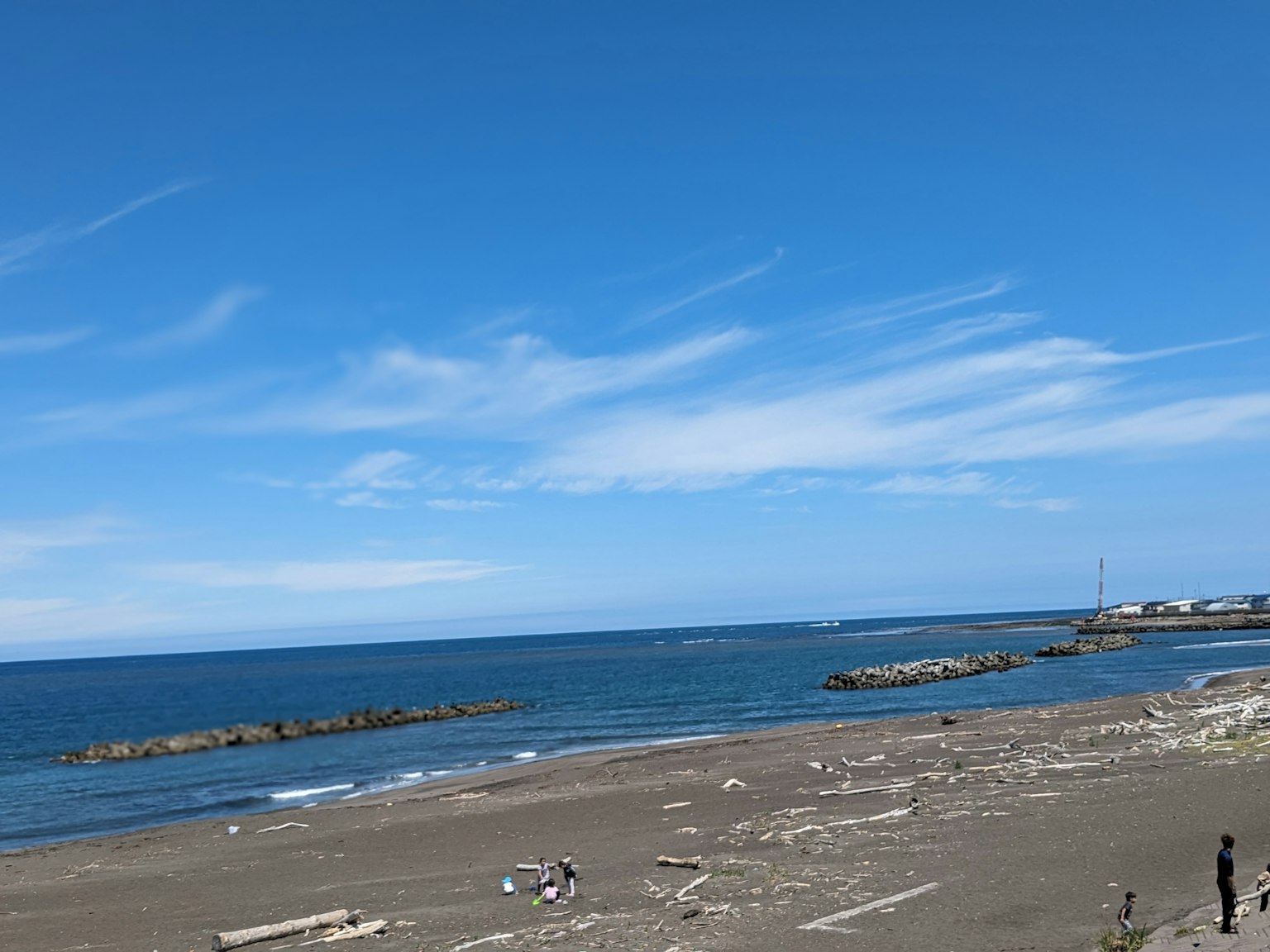 Scena di spiaggia con un ampio cielo blu e oceano persone sulla riva sabbiosa