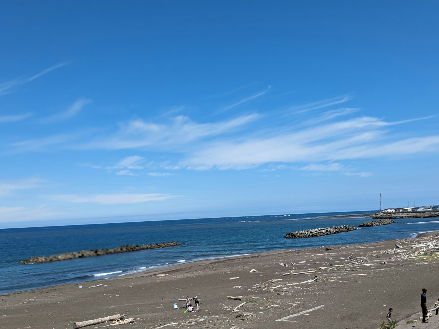 海滩景色，宽广的蓝天和海洋沙滩上有人