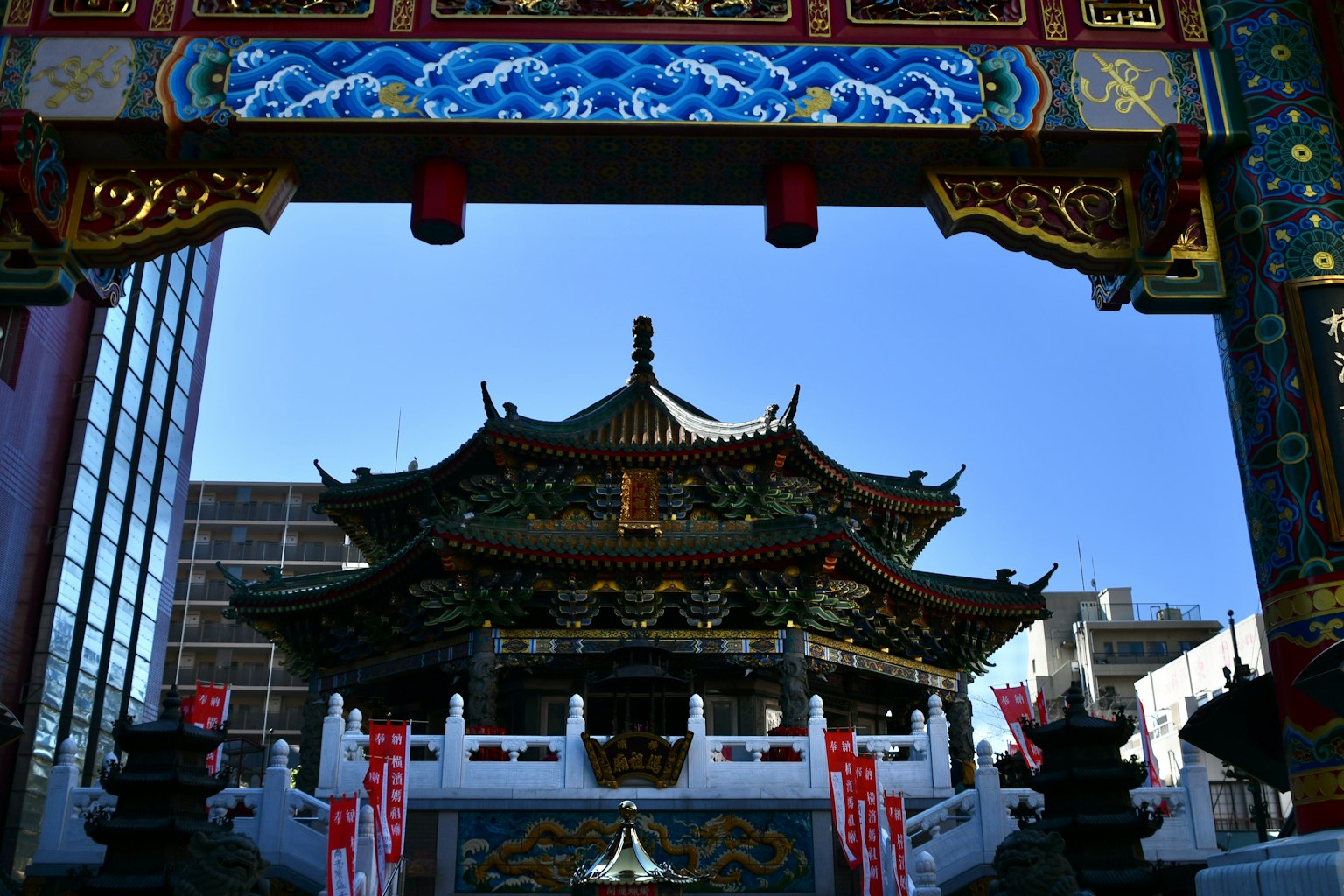 Architecture chinoise traditionnelle visible sous une arche colorée