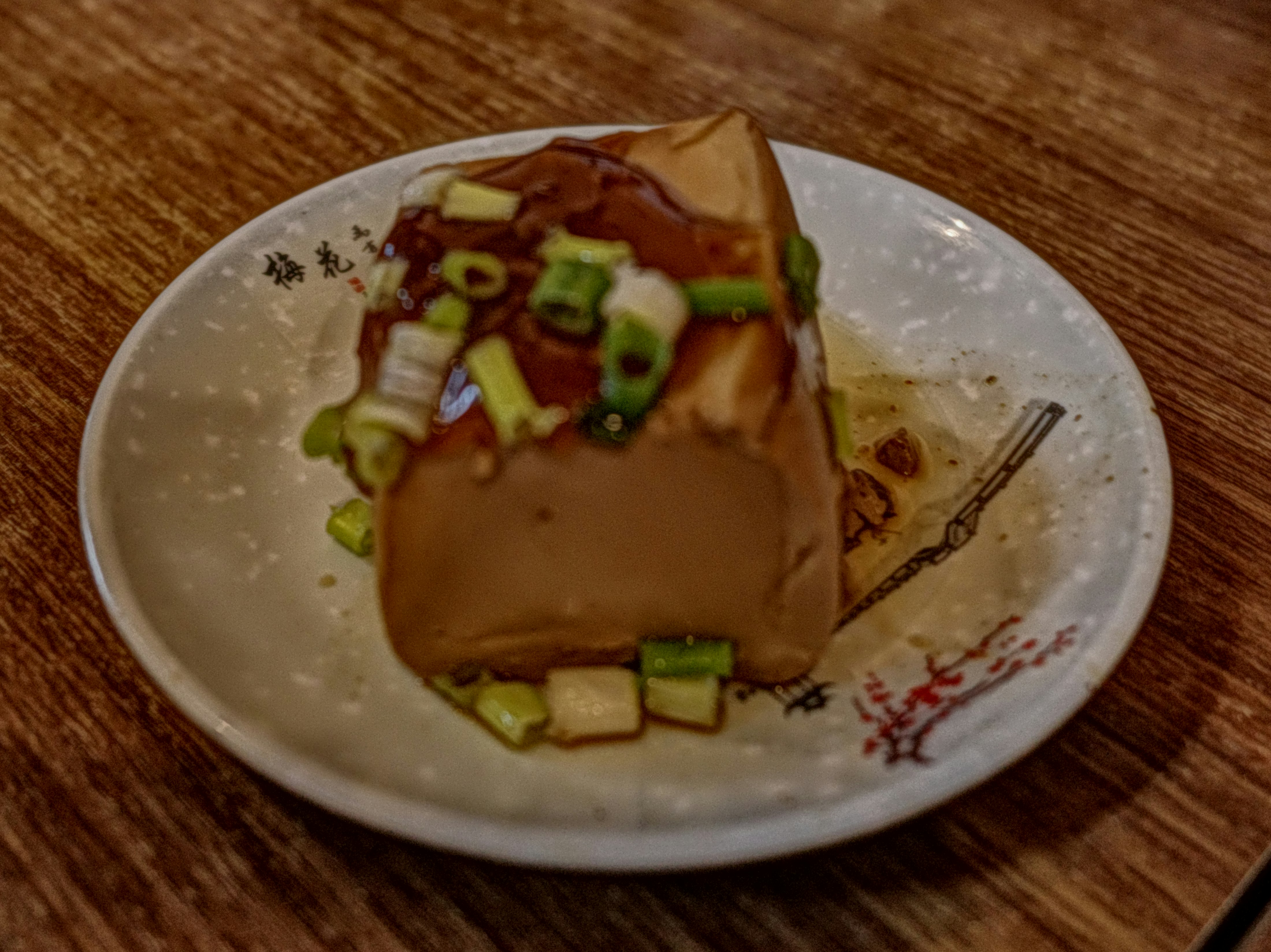 木目のテーブル上の皿に盛られた煮込み料理