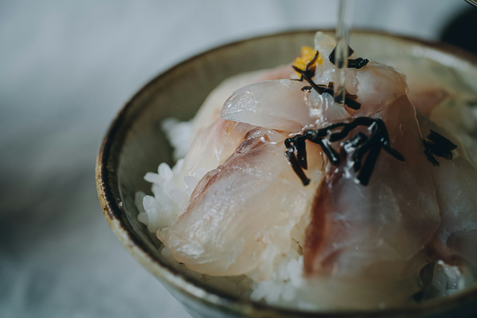 Ciotola di riso guarnita con sashimi fresco e decorazioni vivaci