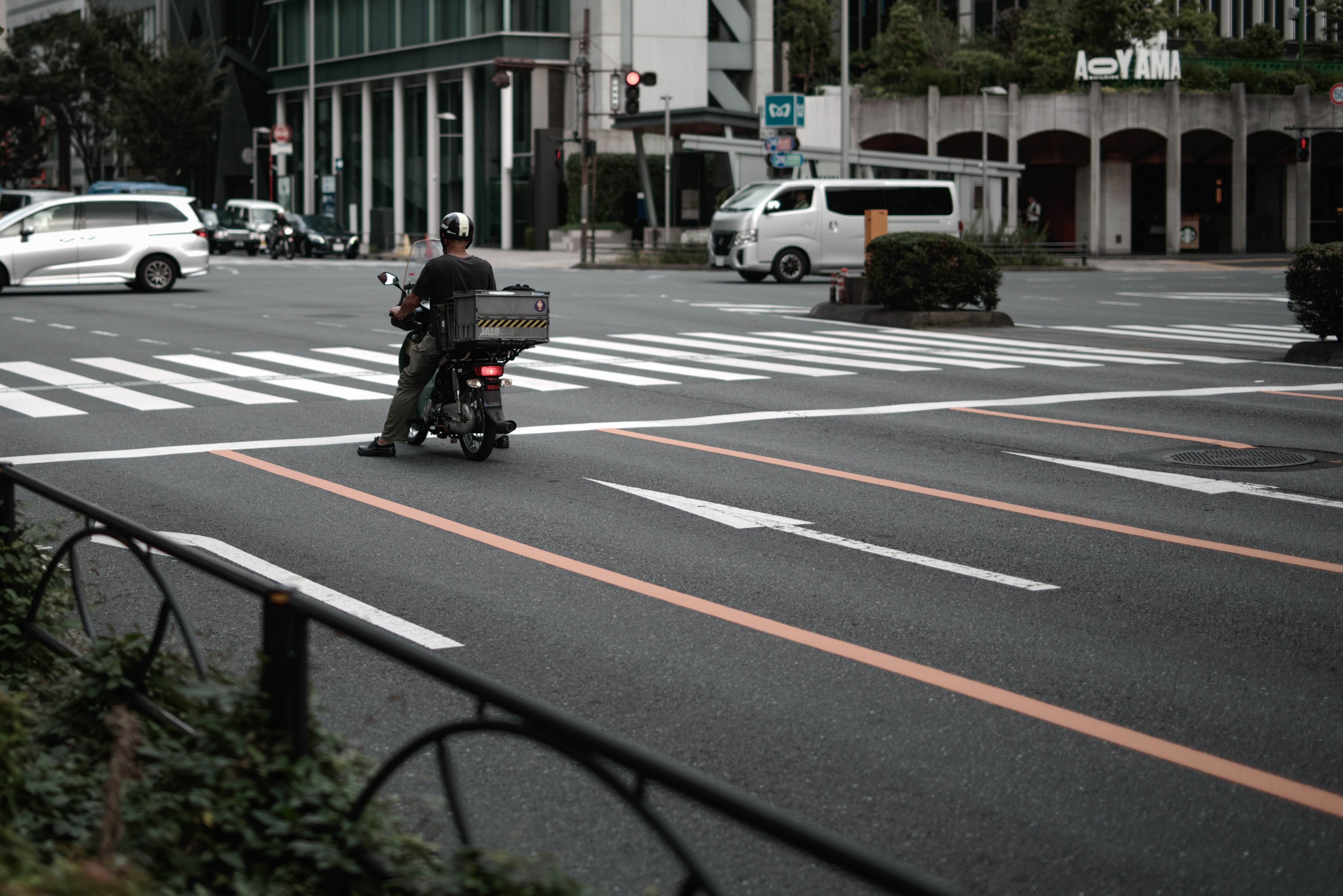 青山一丁目交差点のバイクが走る都心の横断歩道風景
