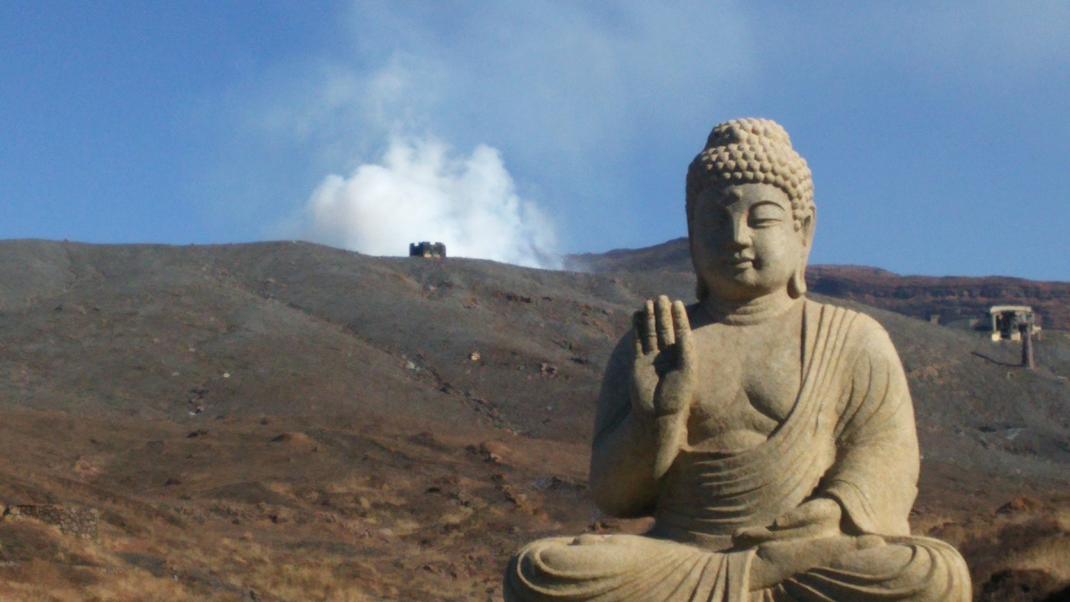 大型石佛像安静地坐在山地风景中