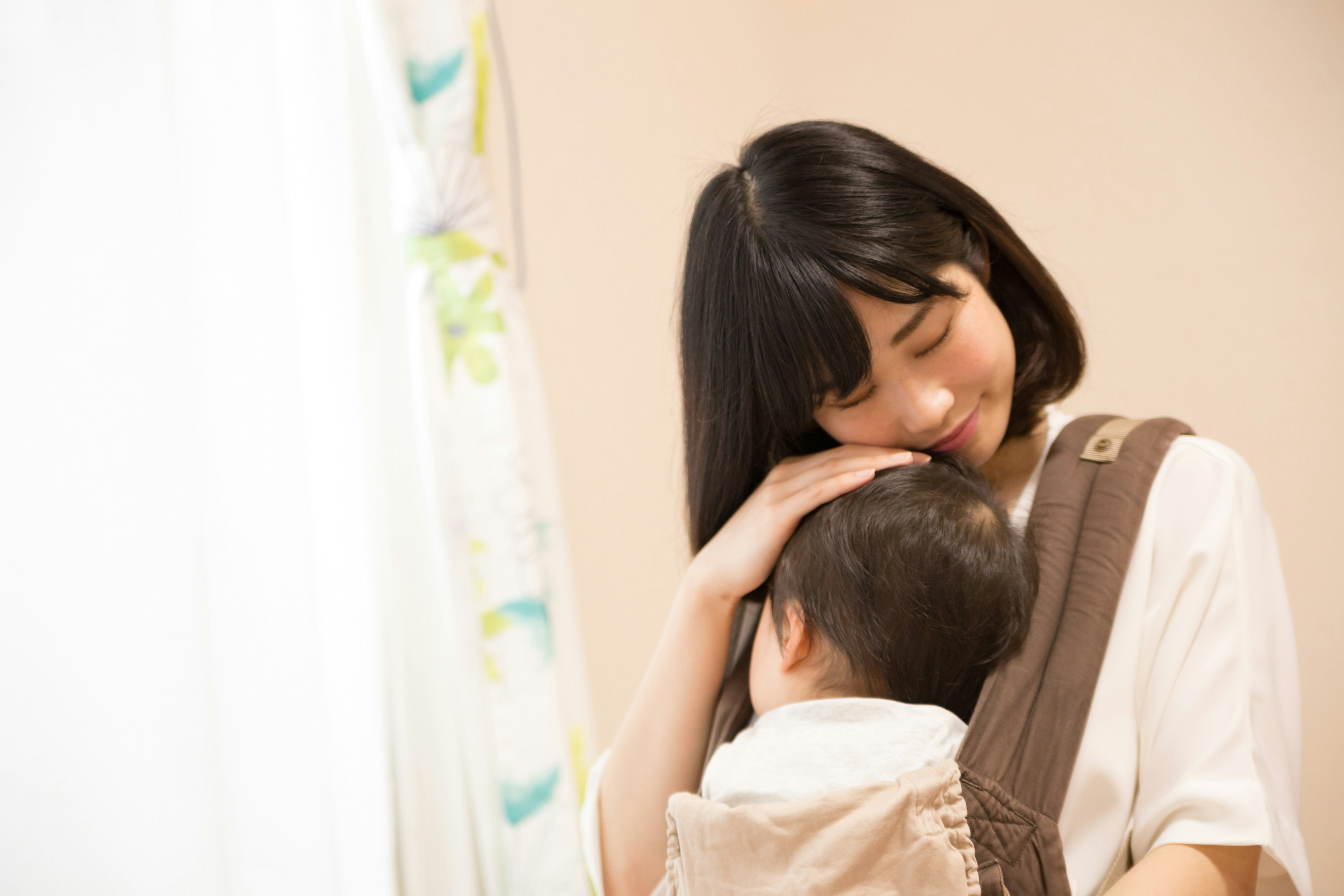 赤ちゃんを抱き寄り添う母親の親子
