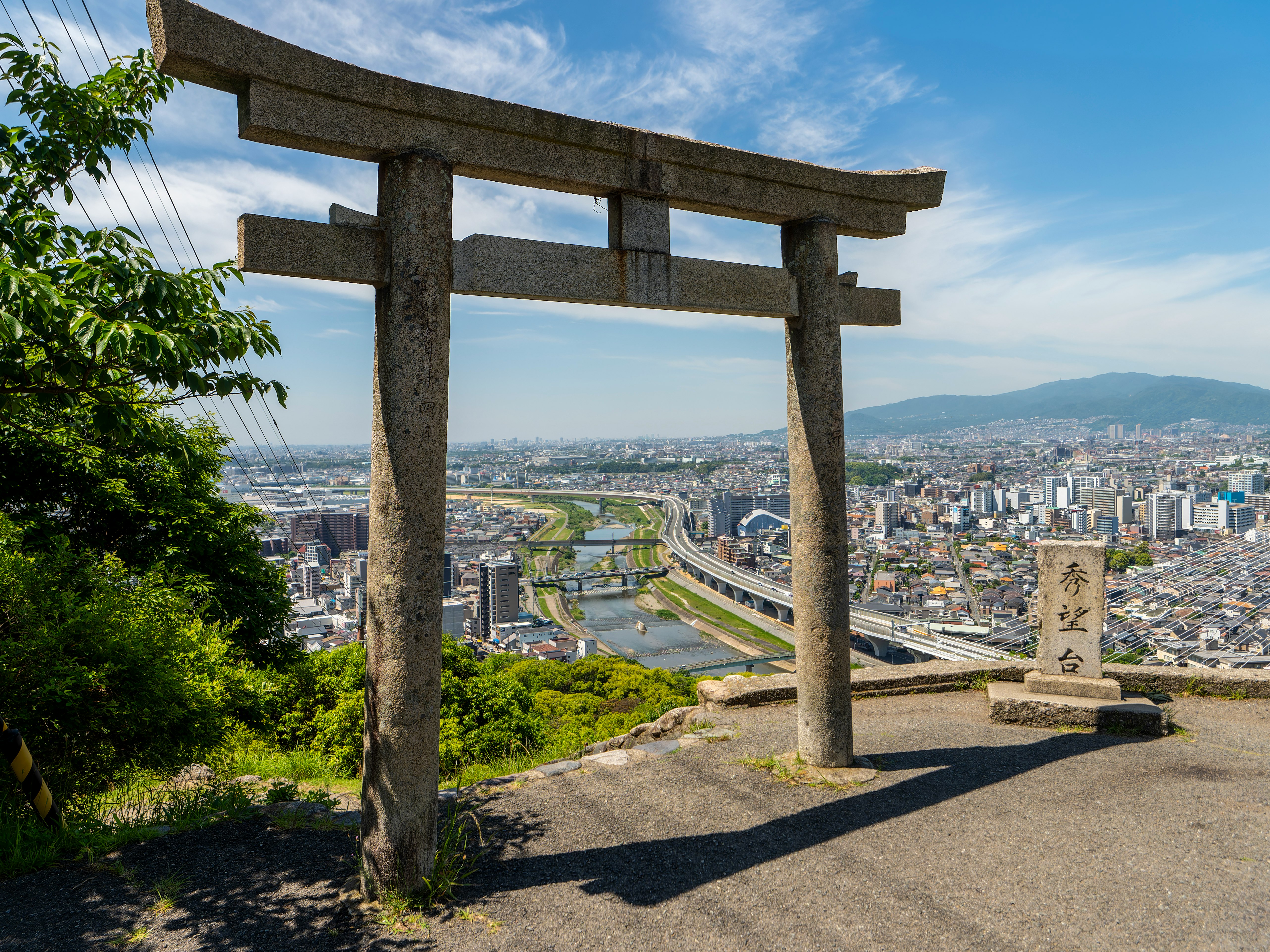 Puerta torii con vista del paisaje urbano a lo largo del río Inagawa en Kawanishi e Ikeda