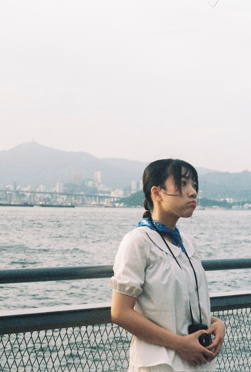 海沿いの遊歩道で海を見つめる人物