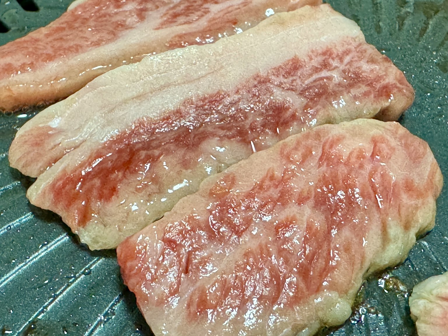 ชิ้นเนื้อที่มีลายมันย่างอยู่บนจาน