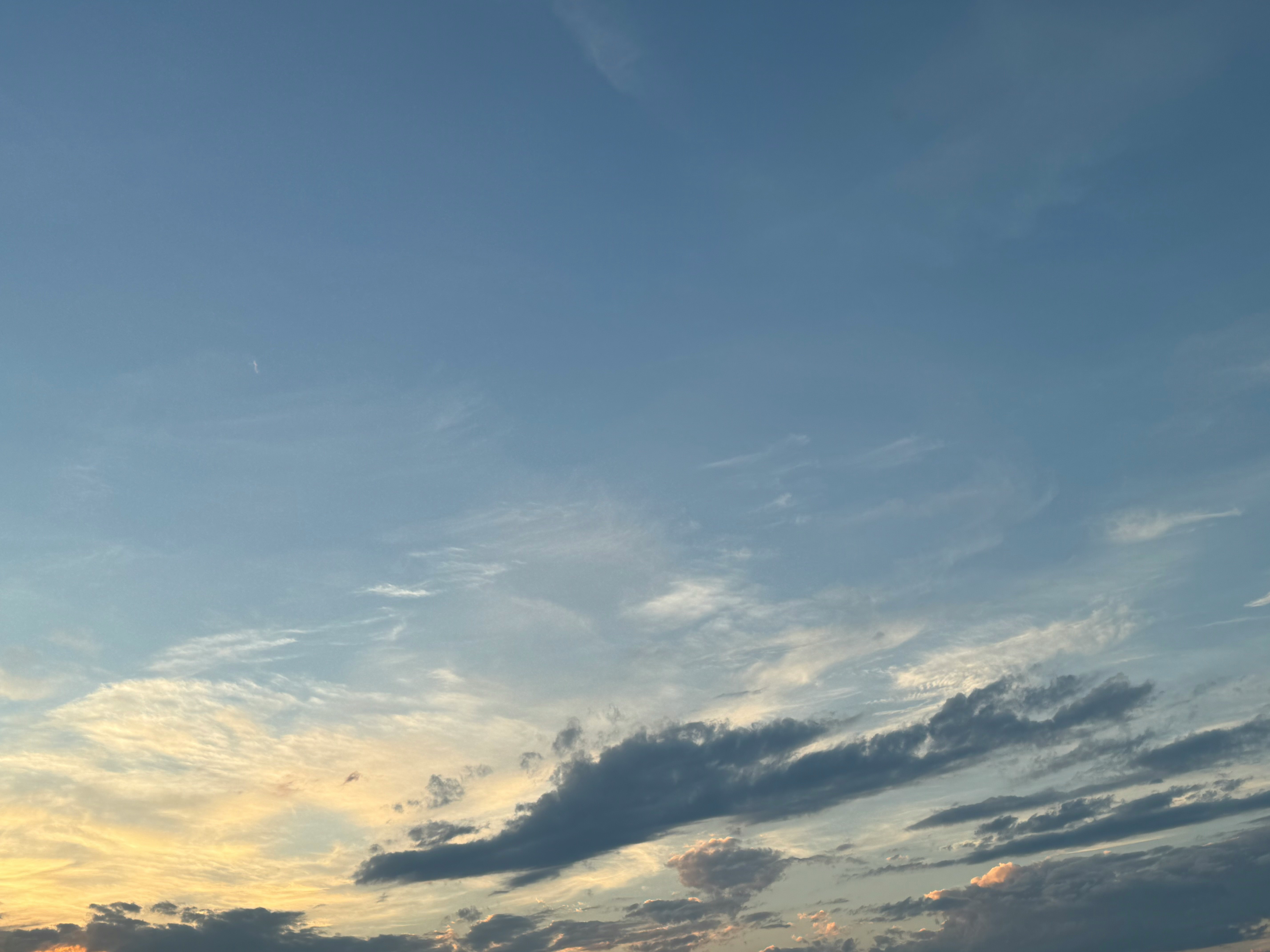 夕焼けの空に広がる雲の流れ