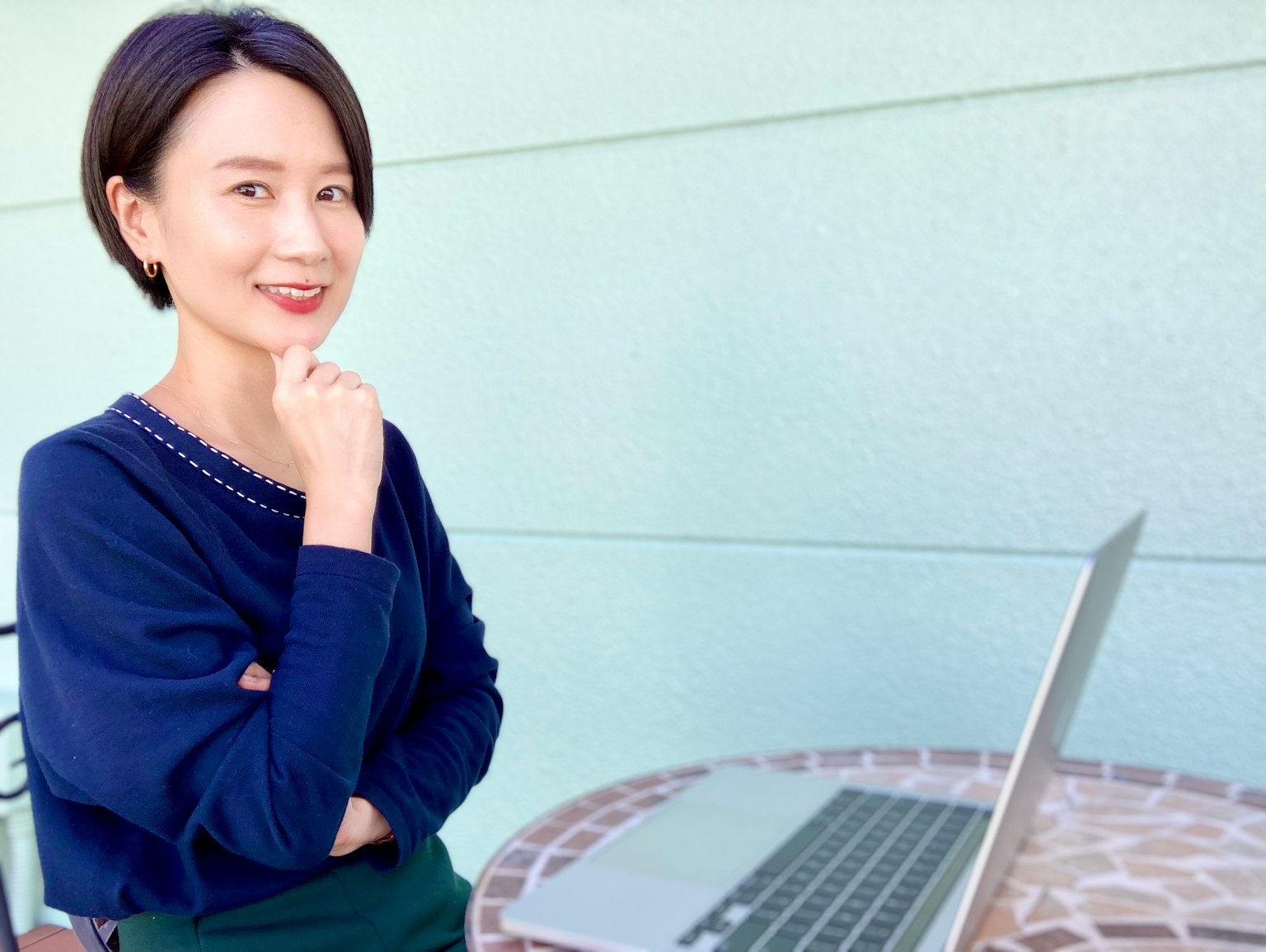 Wanita tersenyum merenung di depan laptop