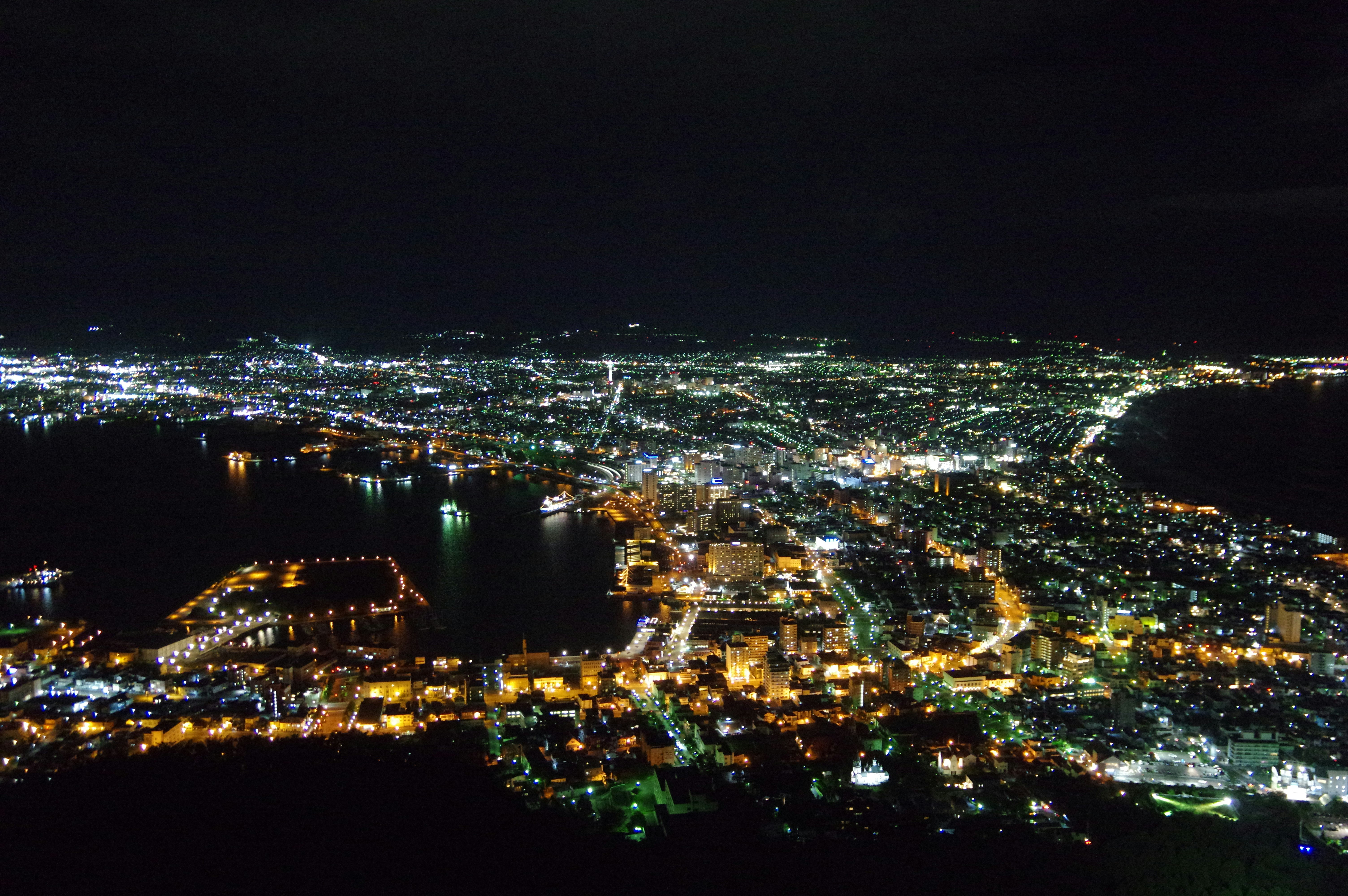 pemandangan kota tepi perairan di malam hari dengan pantulan lampu