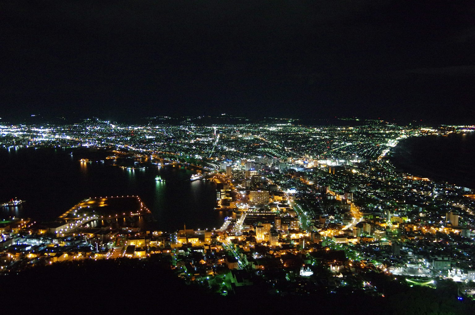 Pemandangan malam kota dengan cahaya berkilau dan fitur air