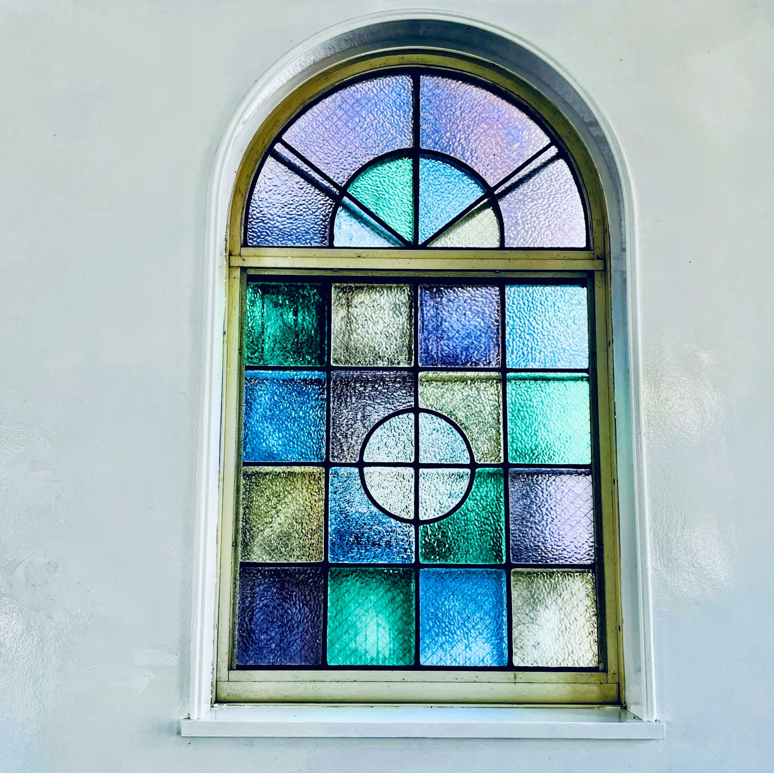 Arched stained glass window vibrant colors and geometric patterns