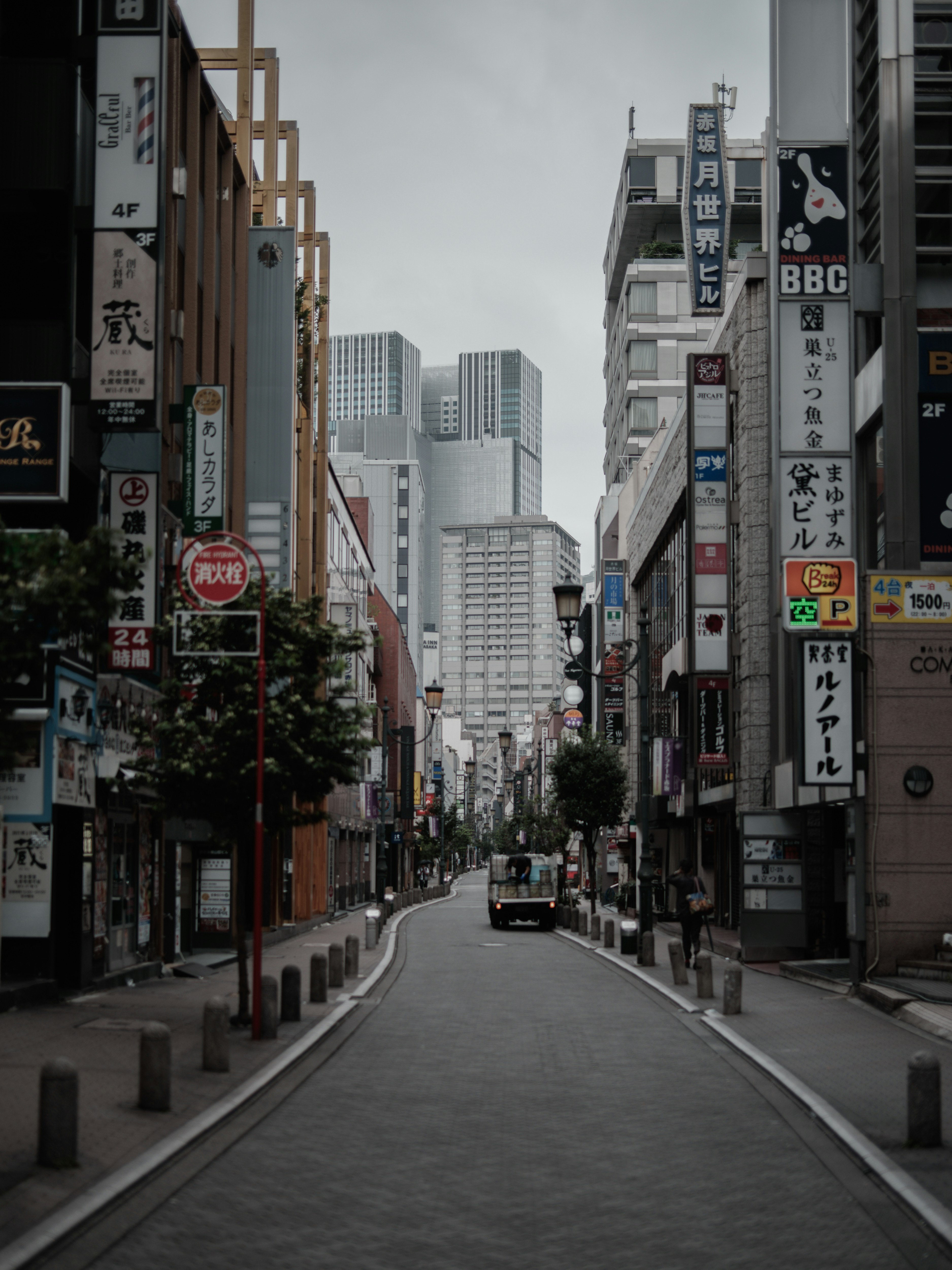 人通りの少ない街路に並ぶ看板のある都市風景