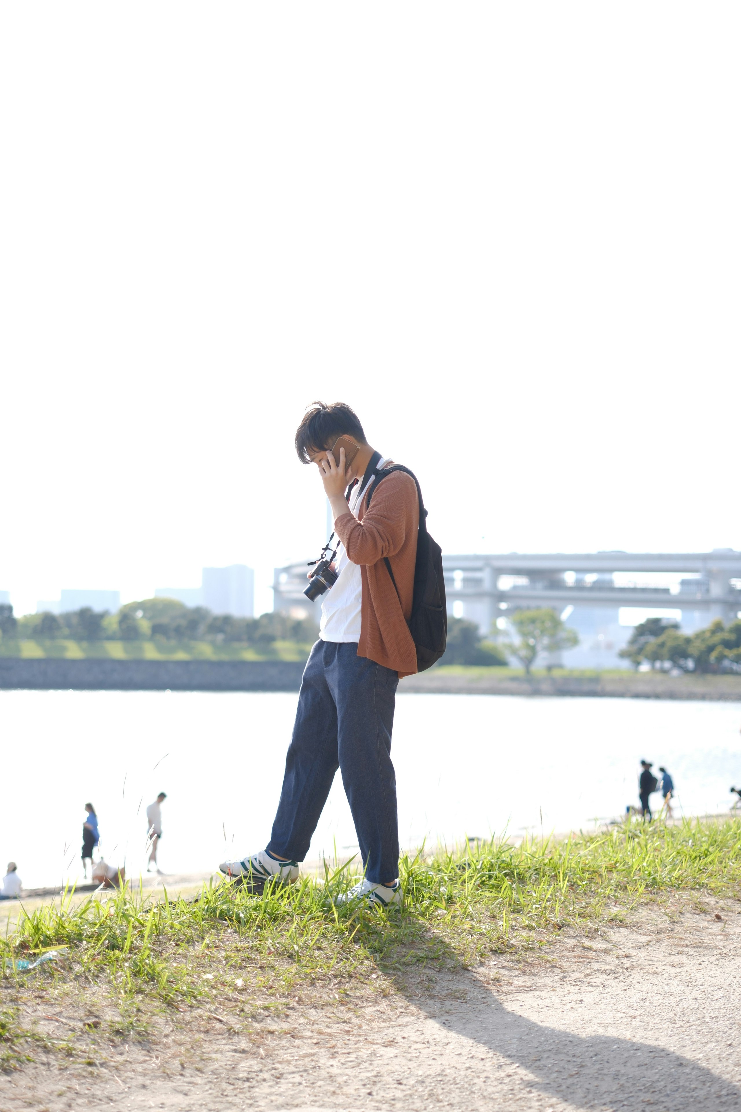川沿いの遊歩道で歩く人物