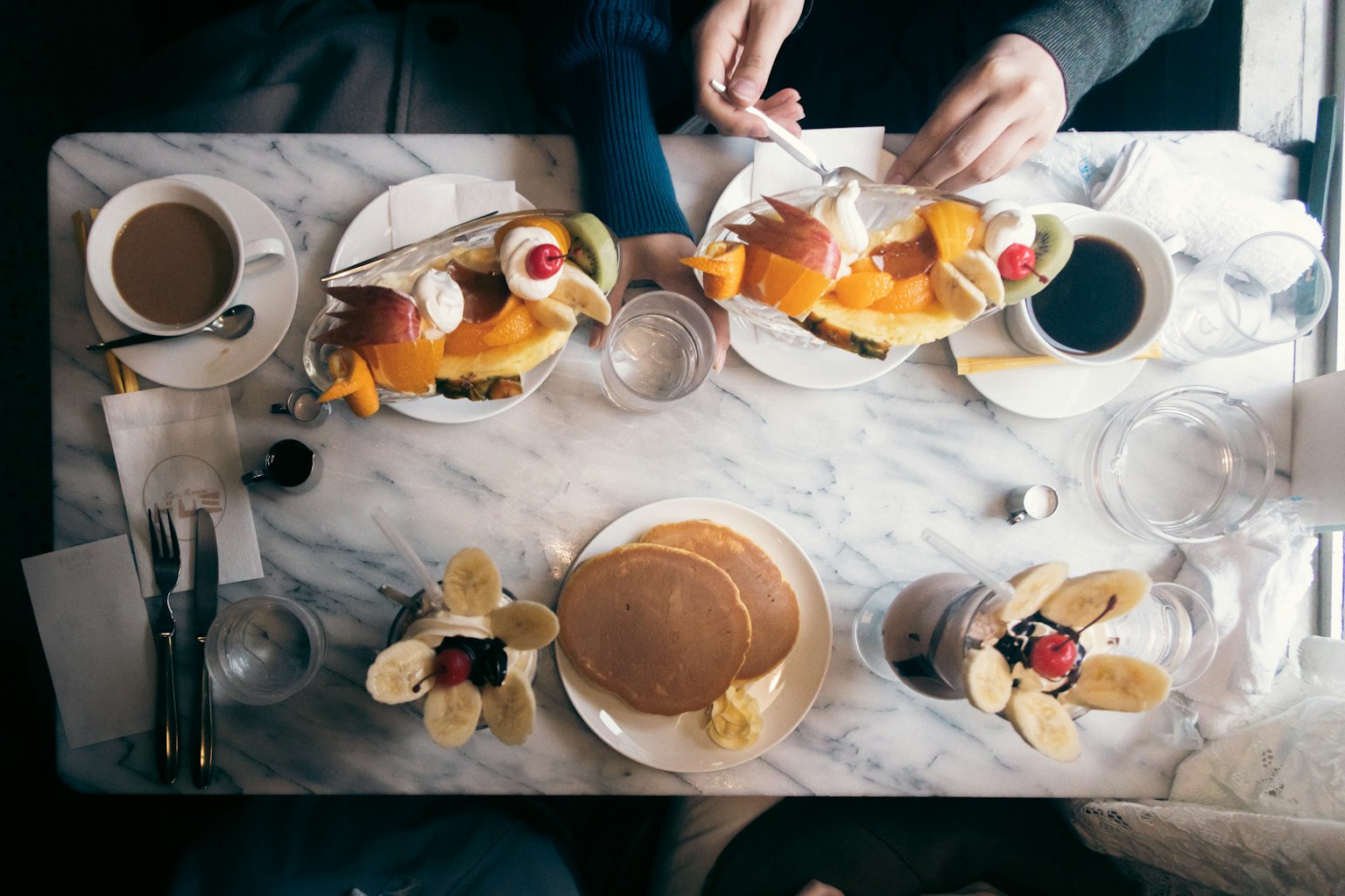 Un petit-déjeuner magnifiquement présenté avec des pancakes et des fruits frais sur une table en marbre