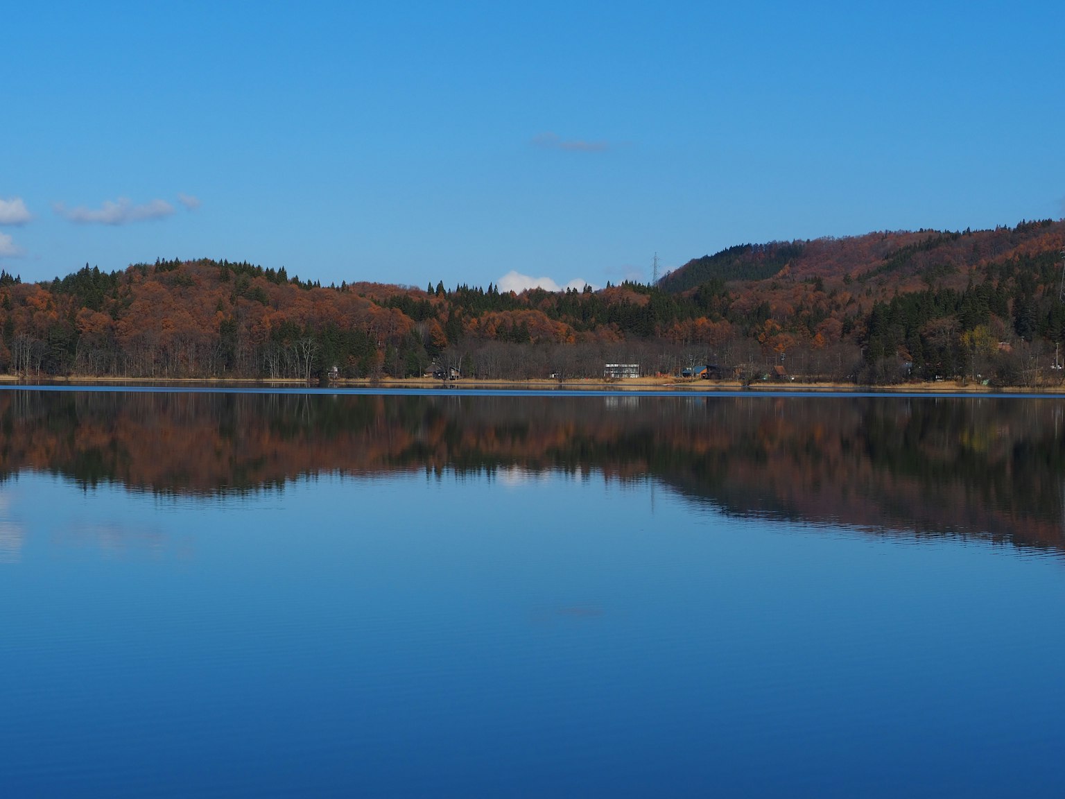 Reflejo sereno del lago con un cielo azul claro