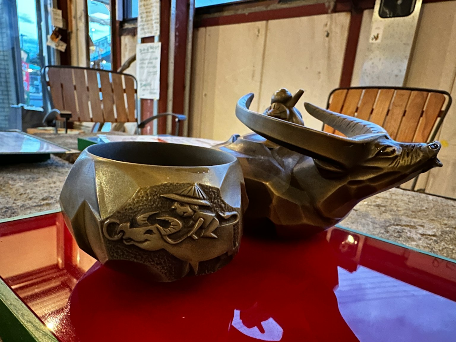 Un pot en céramique en forme de taureau et un bol décoratif sur une table