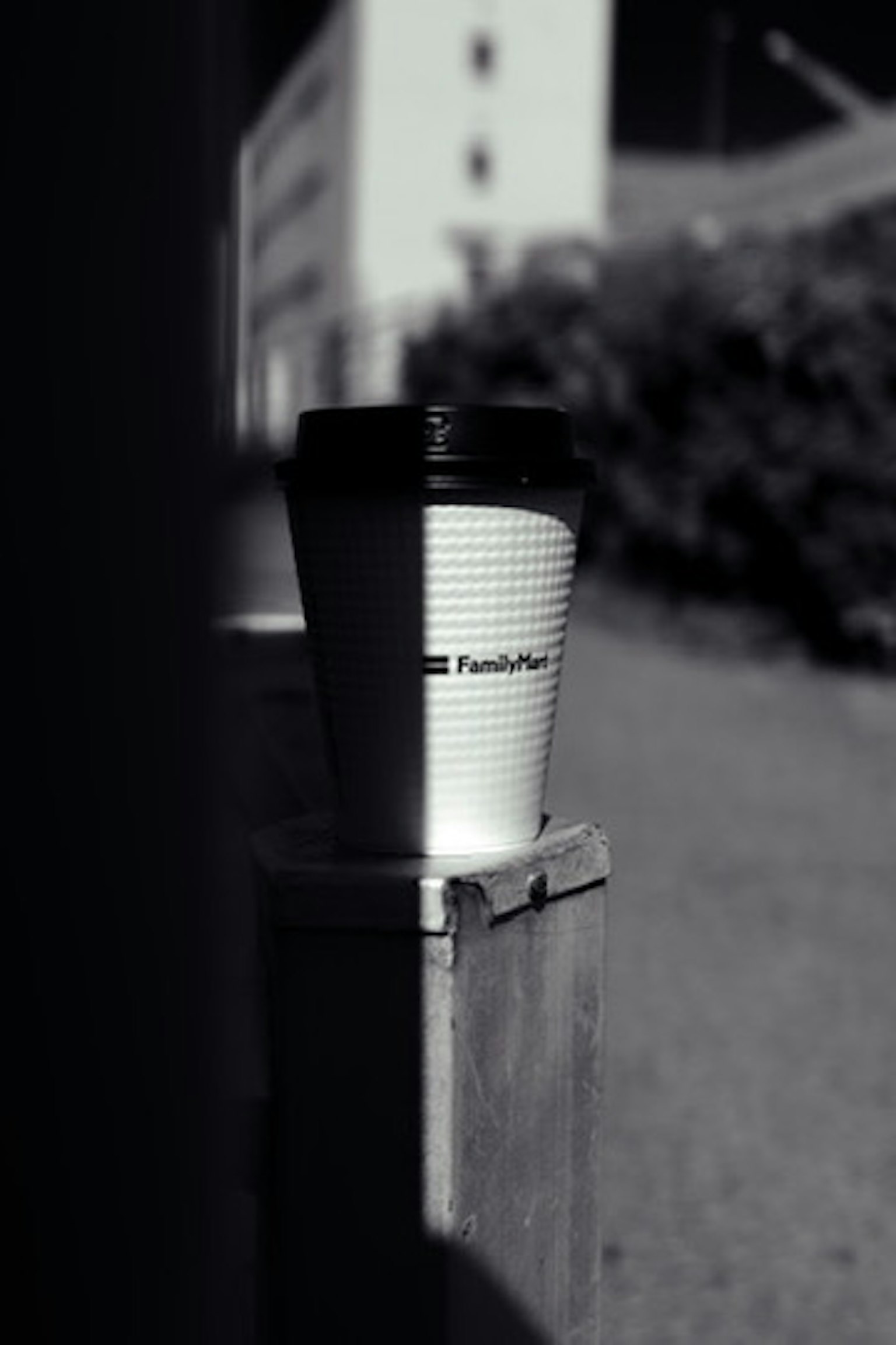黒と白のコーヒーカップが壁のそばに置かれている